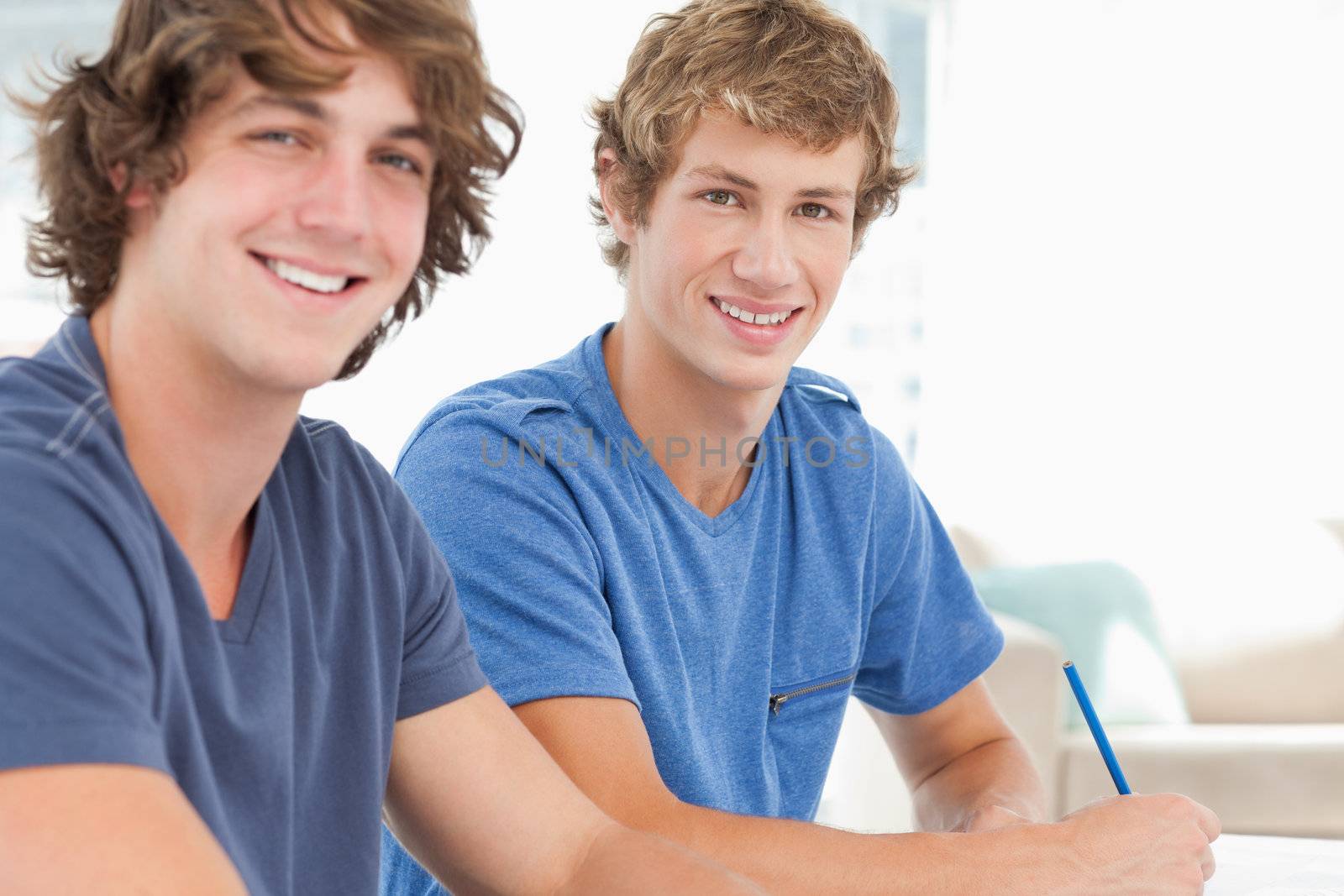A pair of students smiling as they both look into the camera 