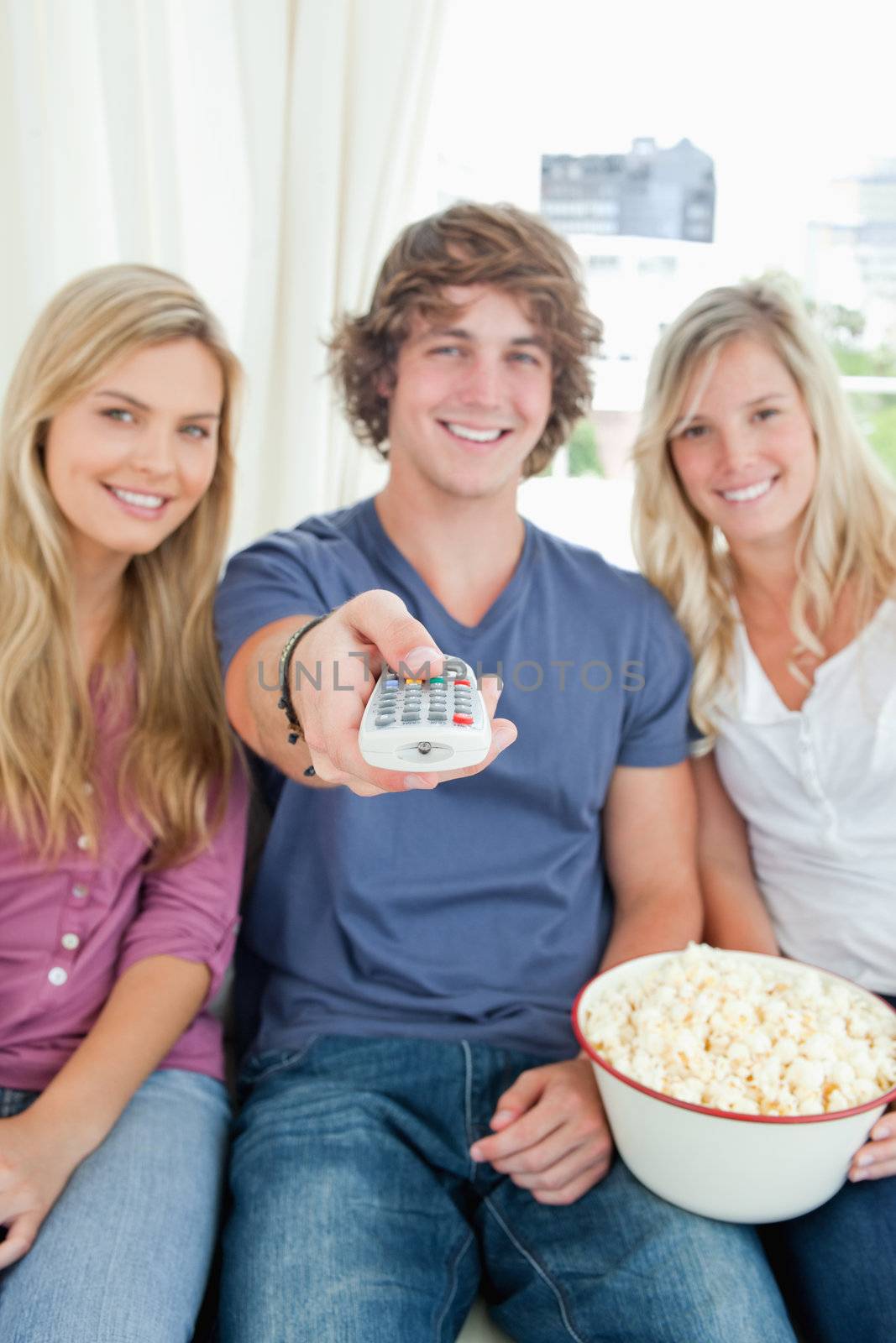 A focused shot on the tv remote as the people eating popcorn are about to use it