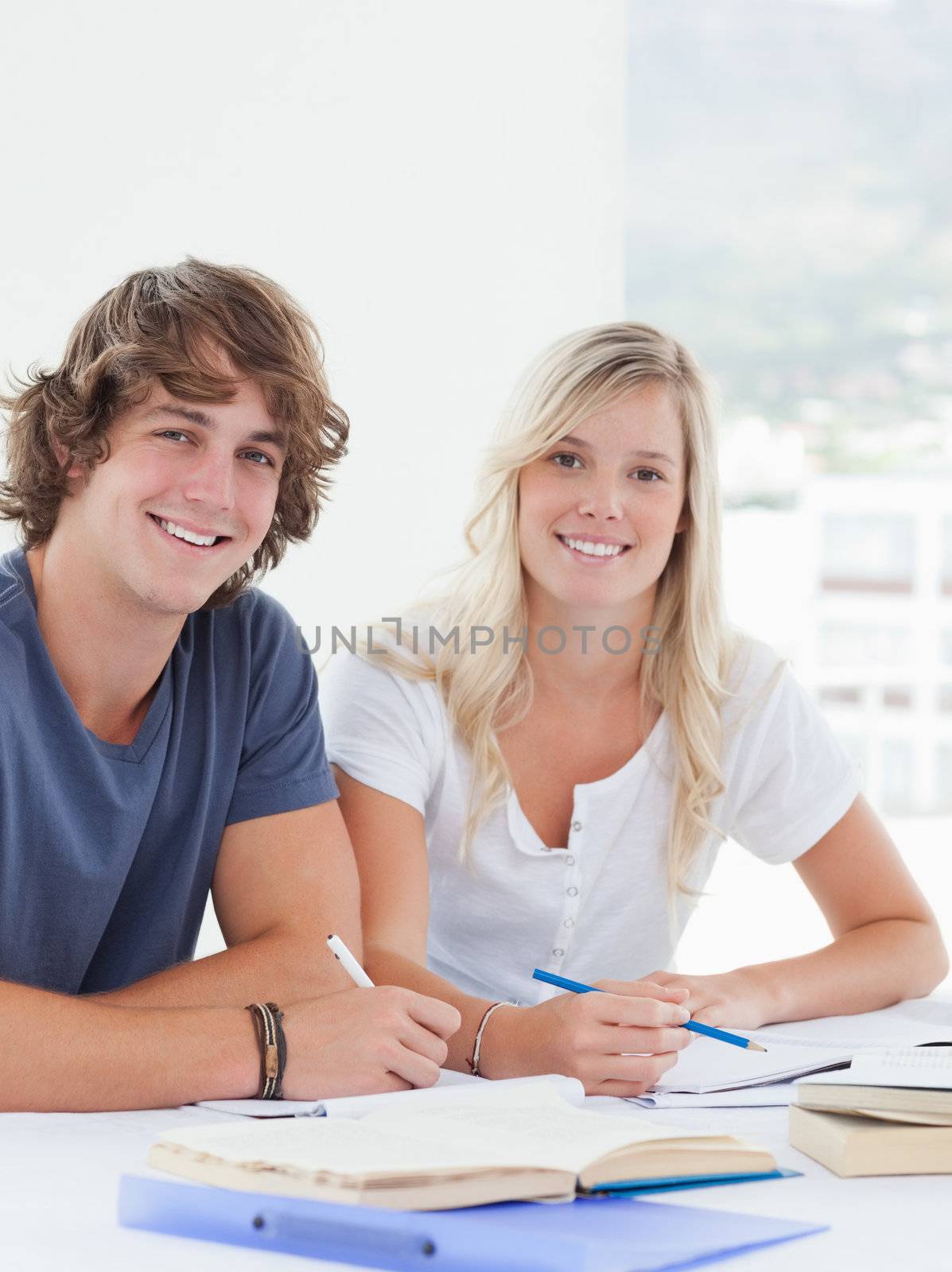 Close up of a smiling group of students looking at the camera  by Wavebreakmedia