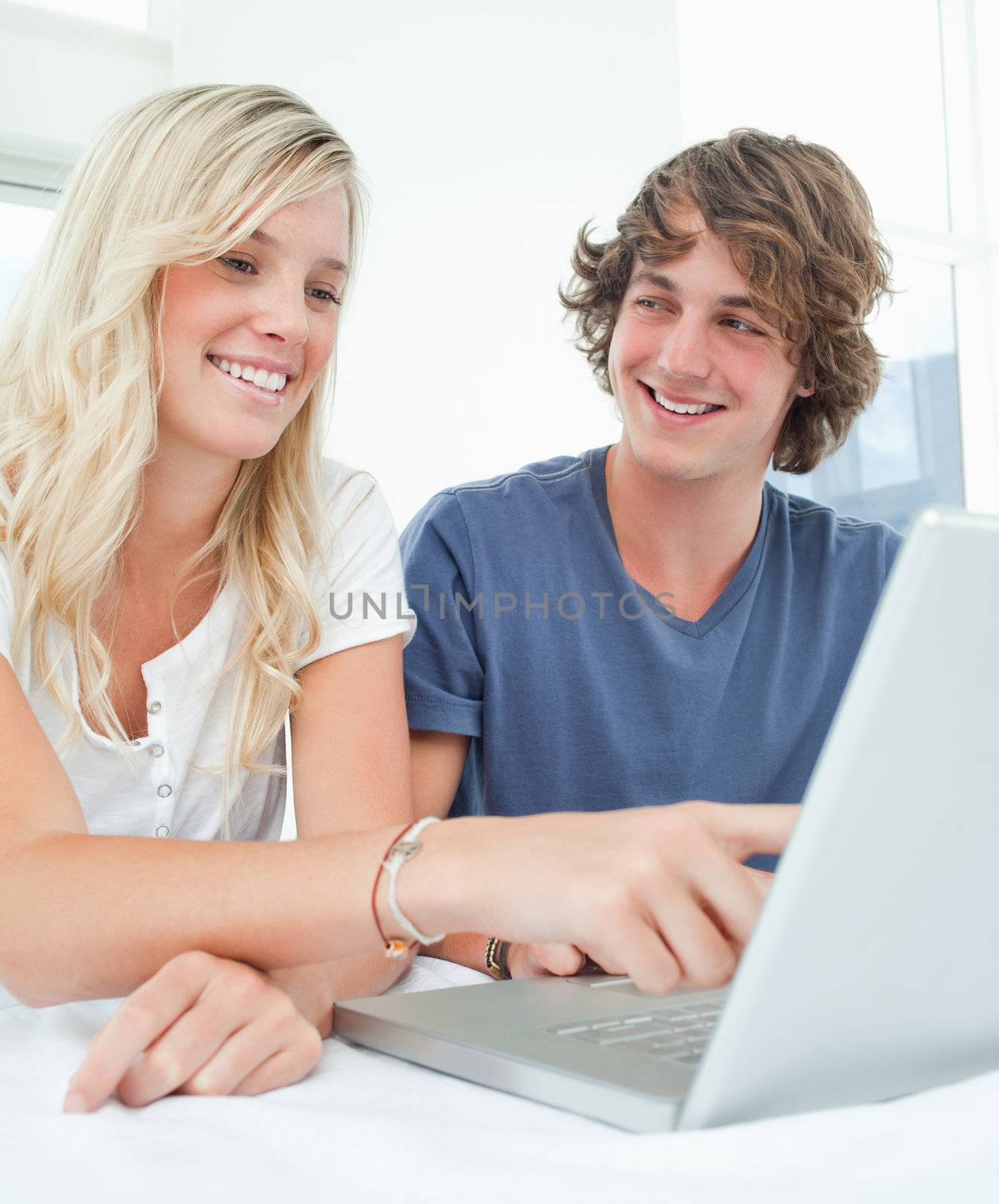 Close up of a man looking at a woman as she points at the screen by Wavebreakmedia