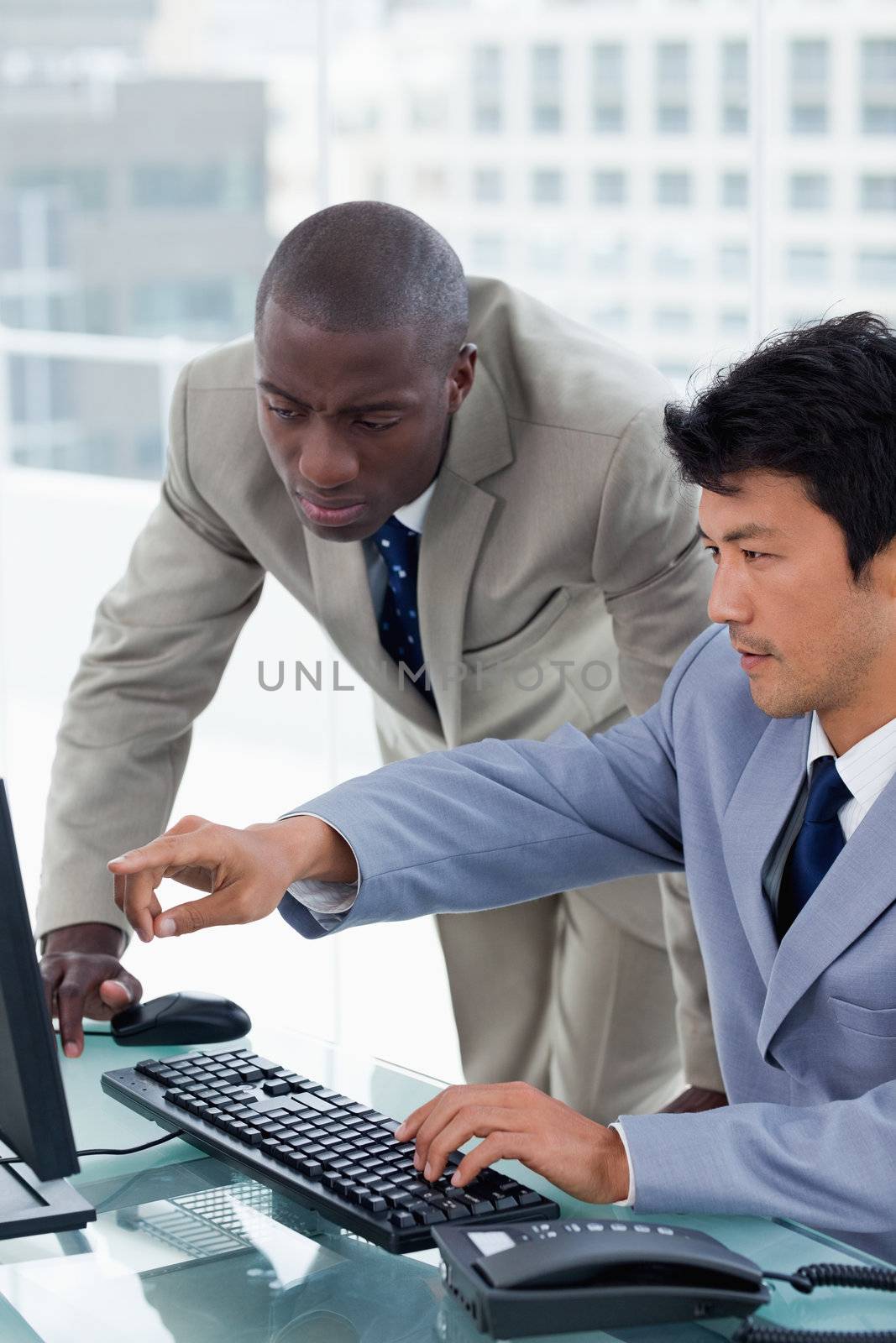 Portrait of an office worker showing something to his colleague in an office