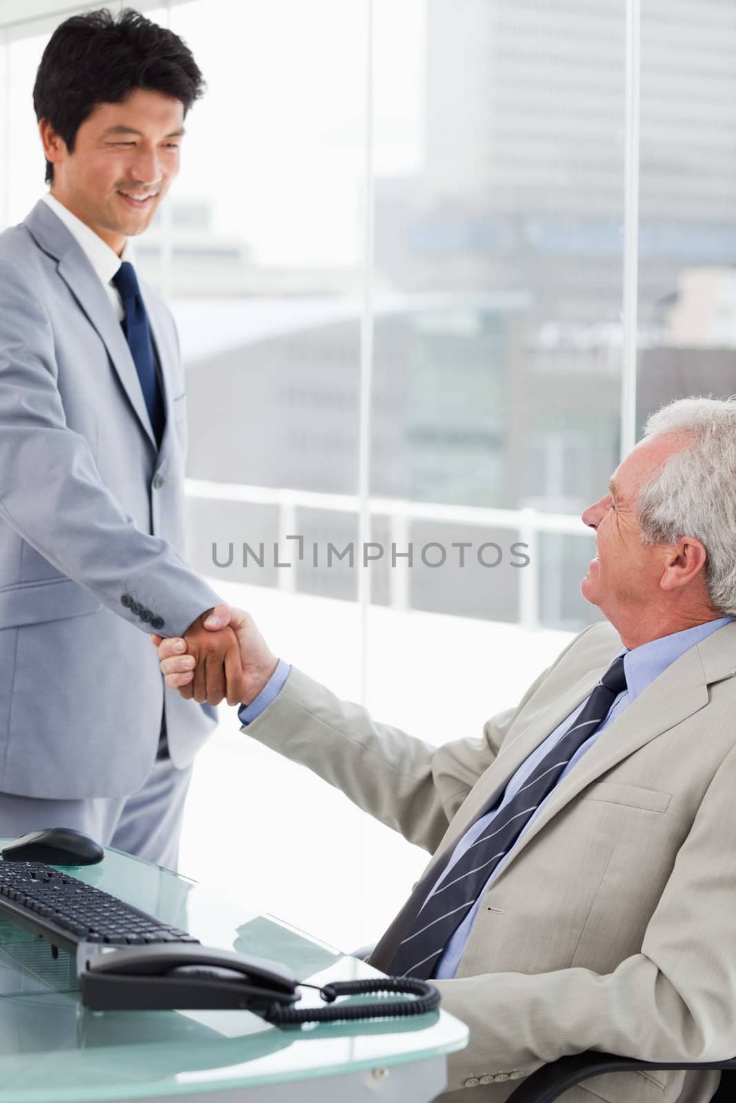 Portrait of a smiling employee shaking the hand of his manager by Wavebreakmedia