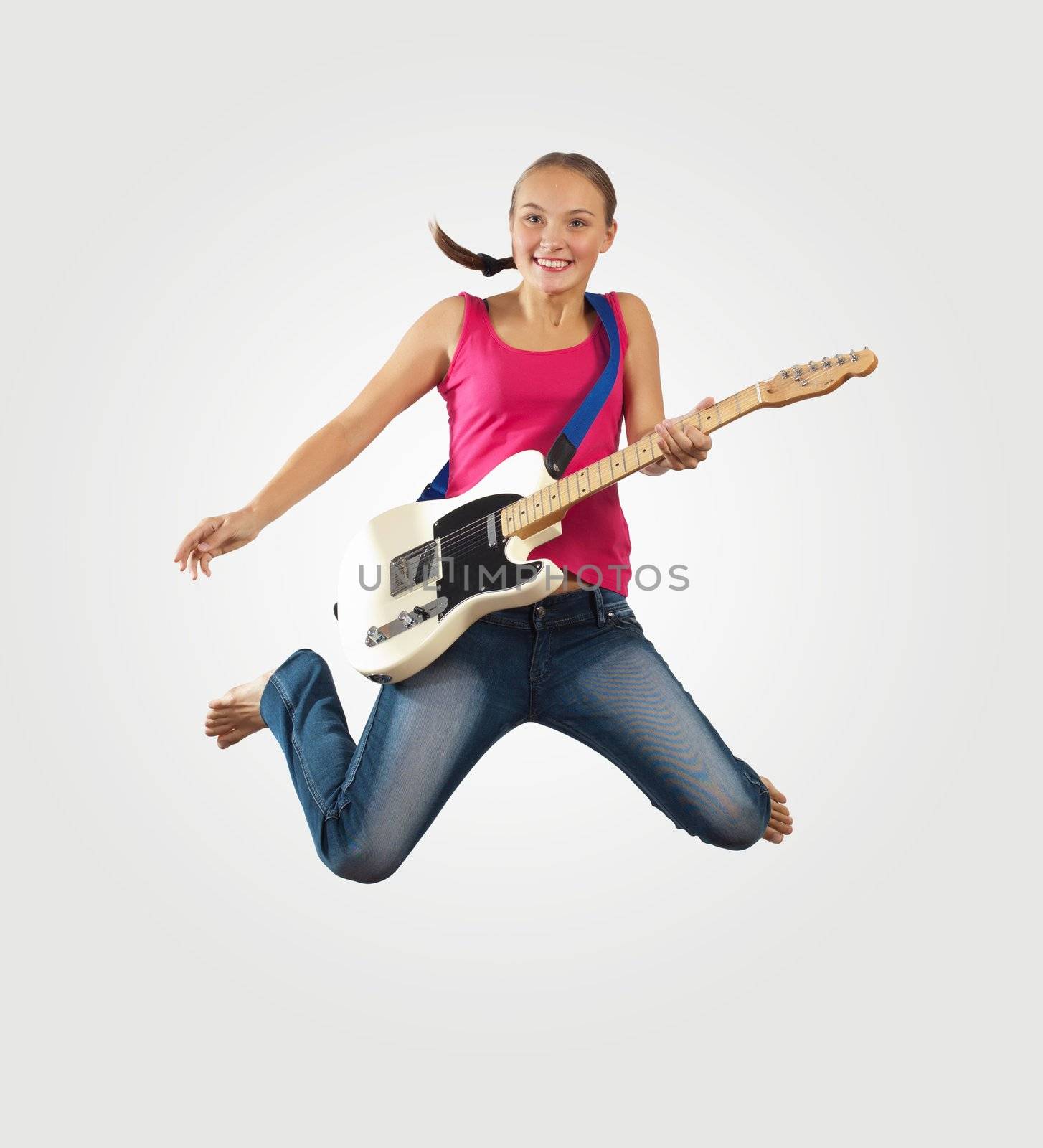 young woman playing on electro guitar and jumping