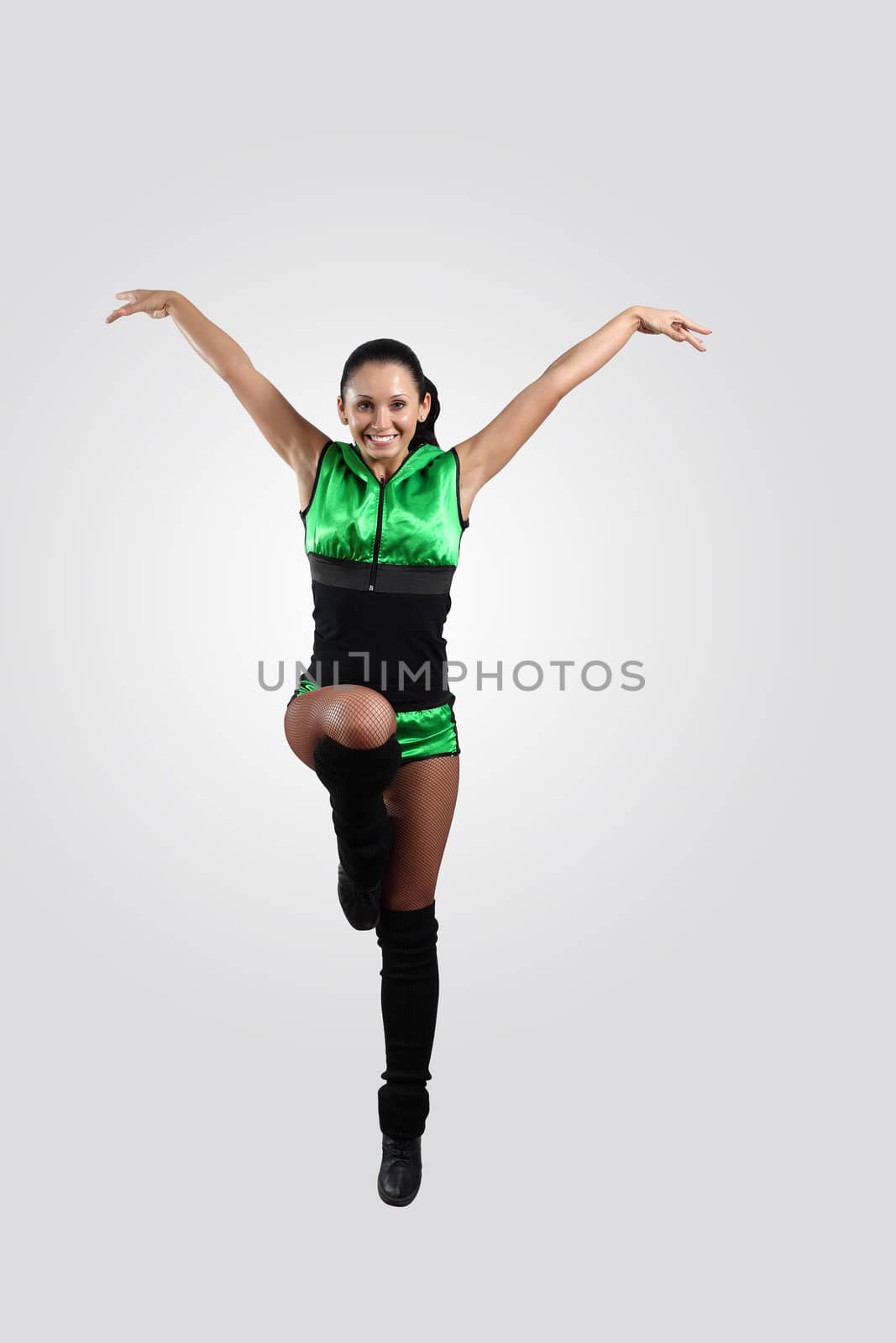 Young female dancer jumping against white background