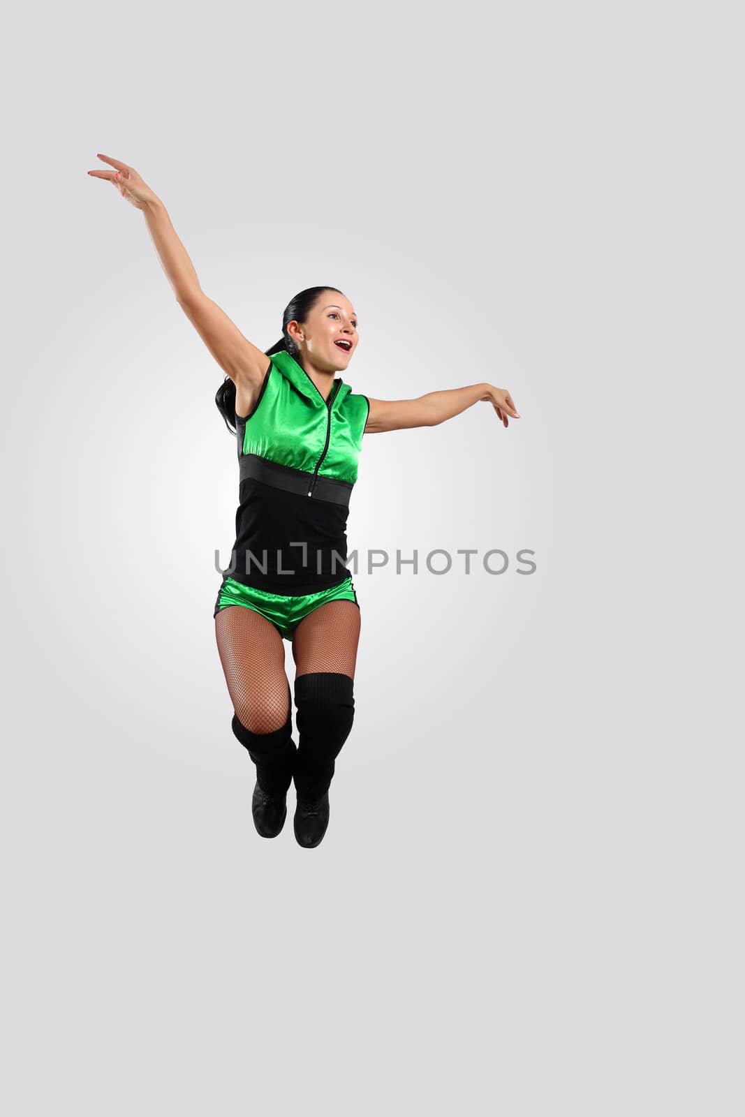 Young female dancer jumping against white background