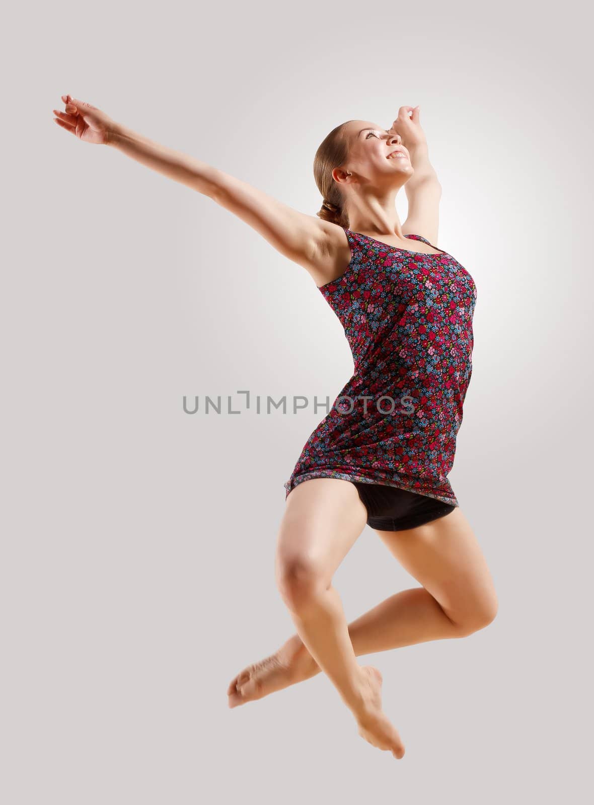 Girl dancing in a color dress with a gray background. isolate