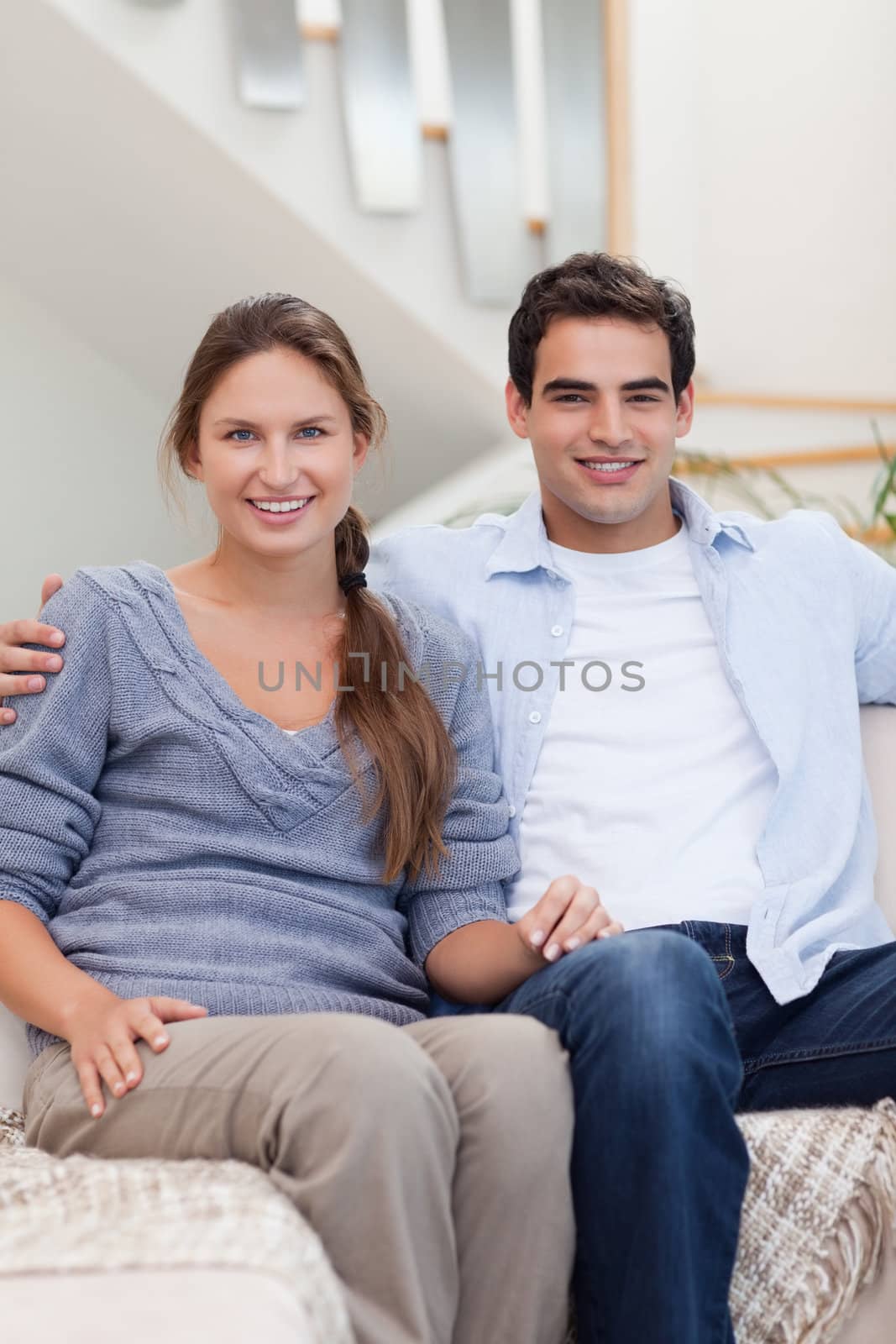 Portrait of a couple sitting on a sofa while looking at the camera