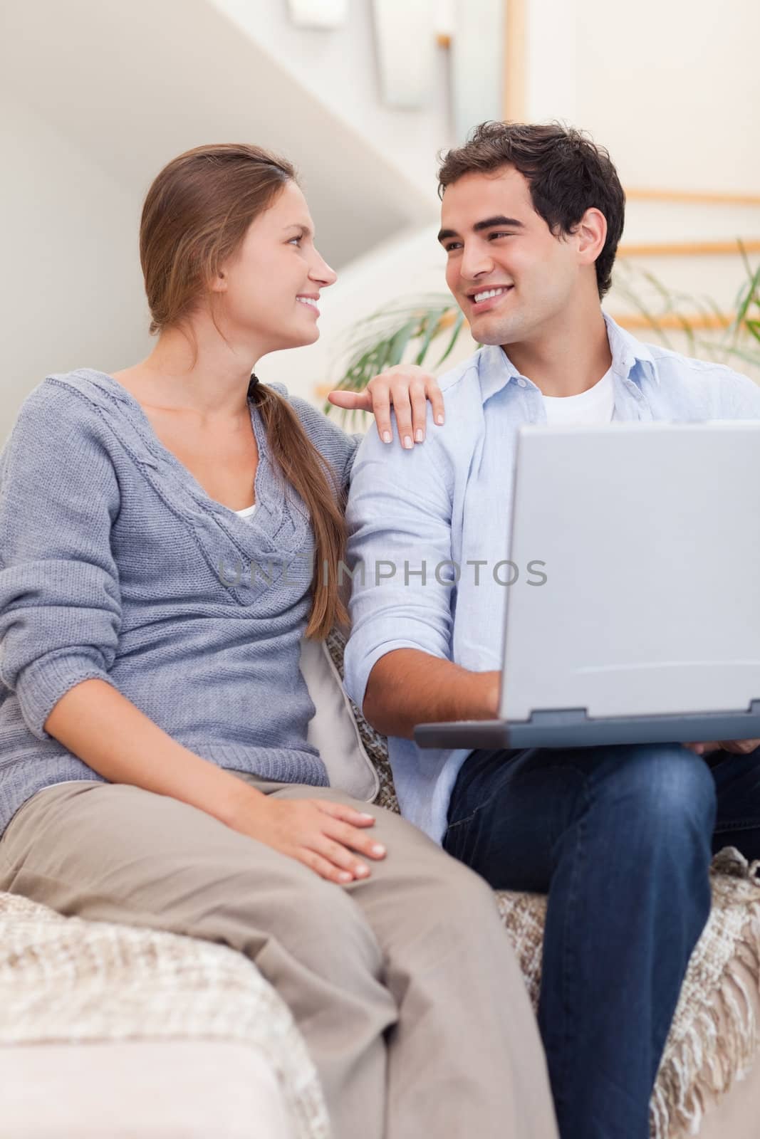 Portrait of a smiling couple using a laptop in their living room