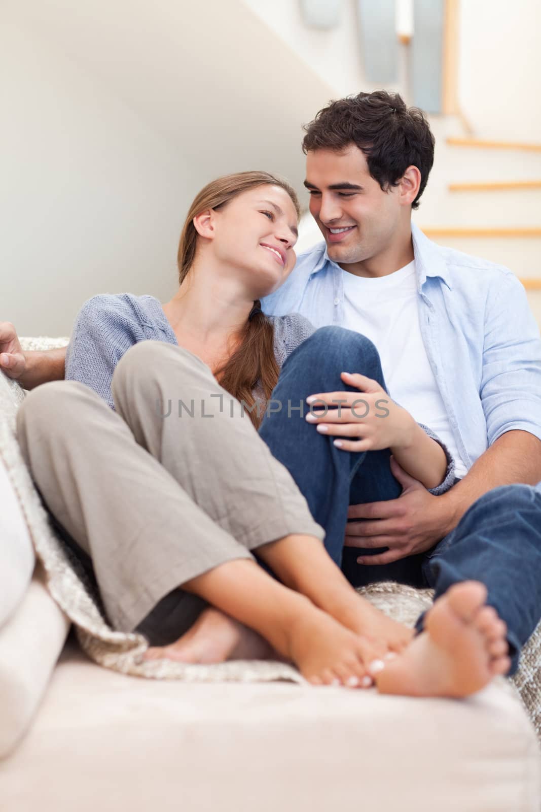 Portrait of a couple lying on a couch while looking at each other