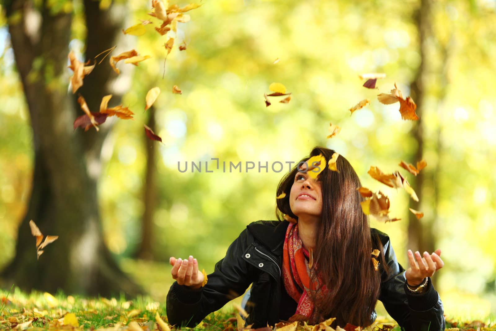woman drop leaves in autumn park by Yellowj