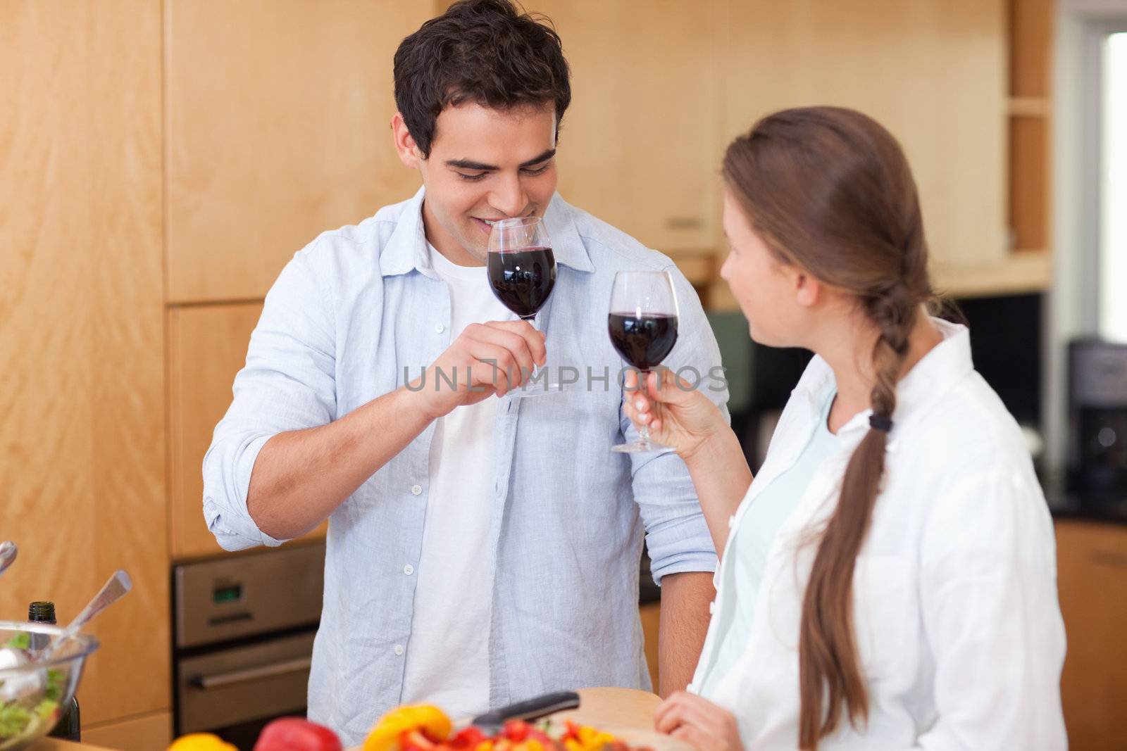 Couple drinking a glass of red wine in their kitchen
