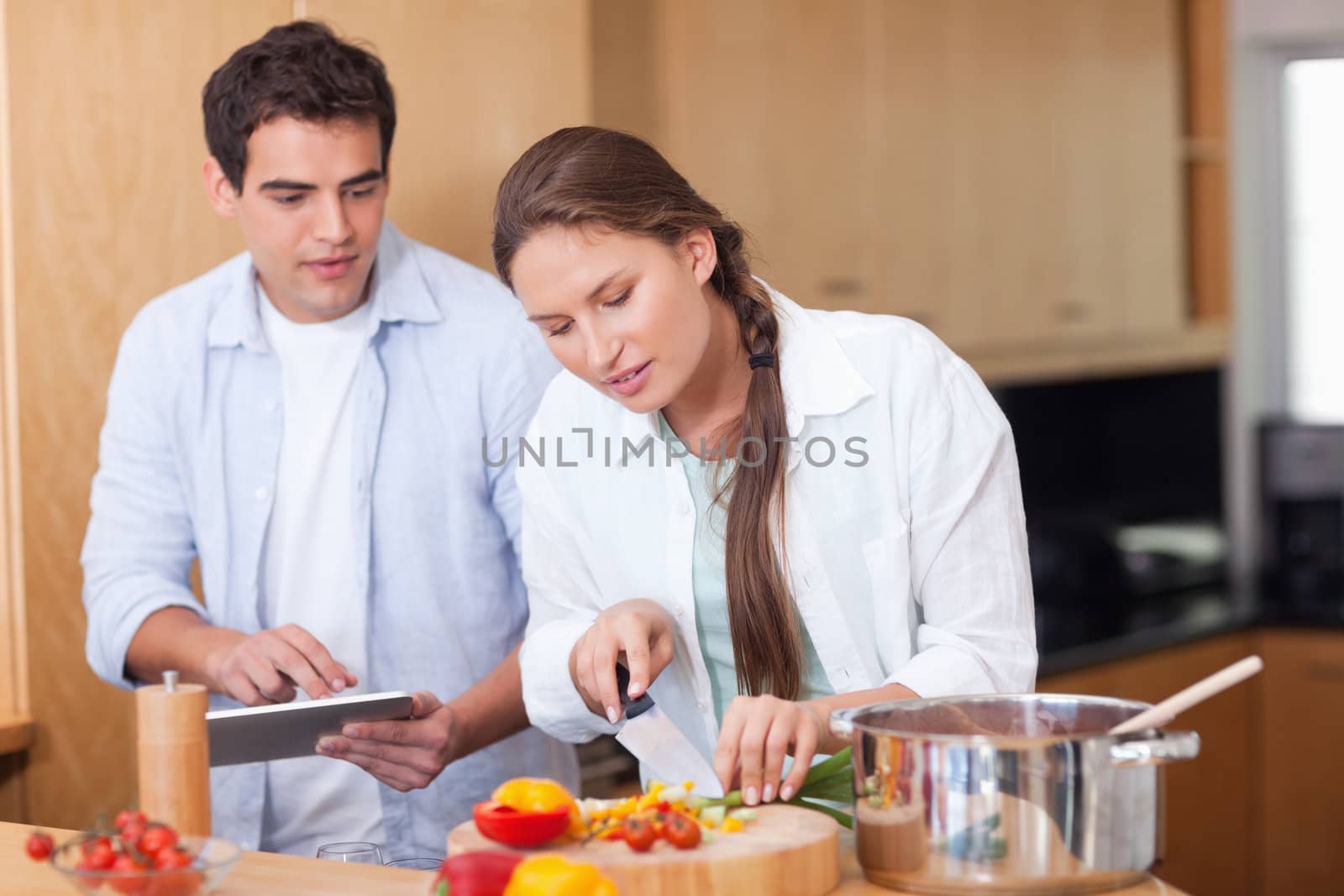 Modern couple using a tablet computer to cook in their kitchen