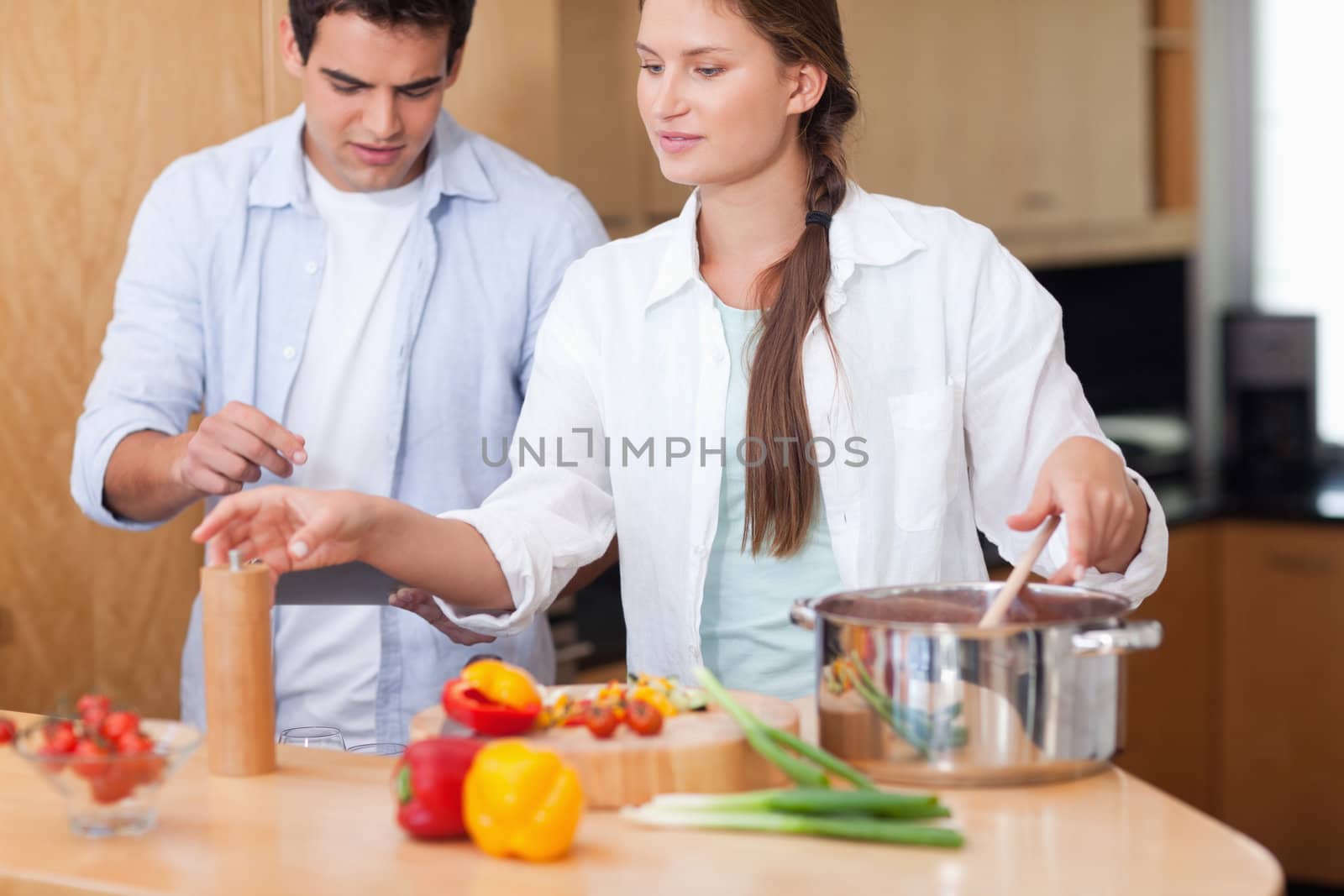 Cute couple using a tablet computer to cook in their kitchen