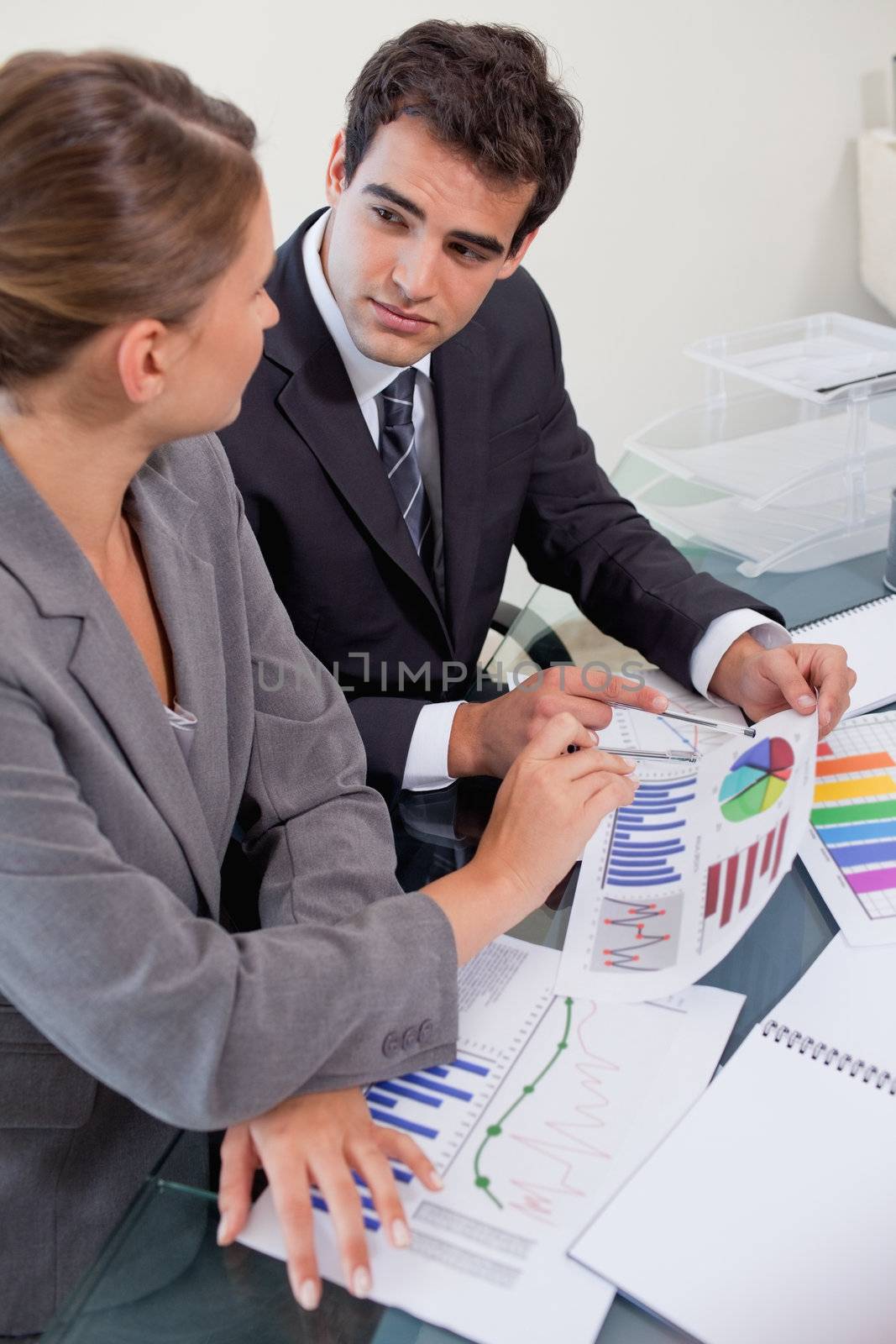 Portrait of a business team studying statistics in a meeting room while looking at each other