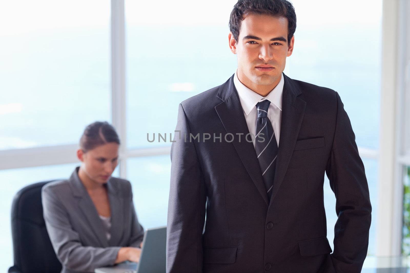 Young businessman with his secretary behind him