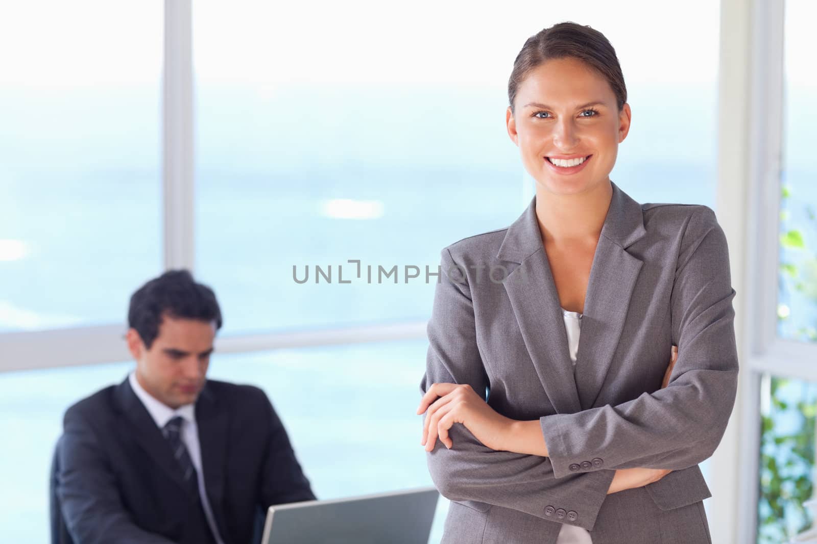 Smiling young tradeswoman with arms folded