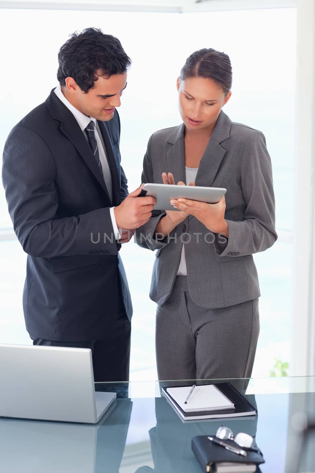 Tradesman explaining functionality of tablet to his colleague by Wavebreakmedia