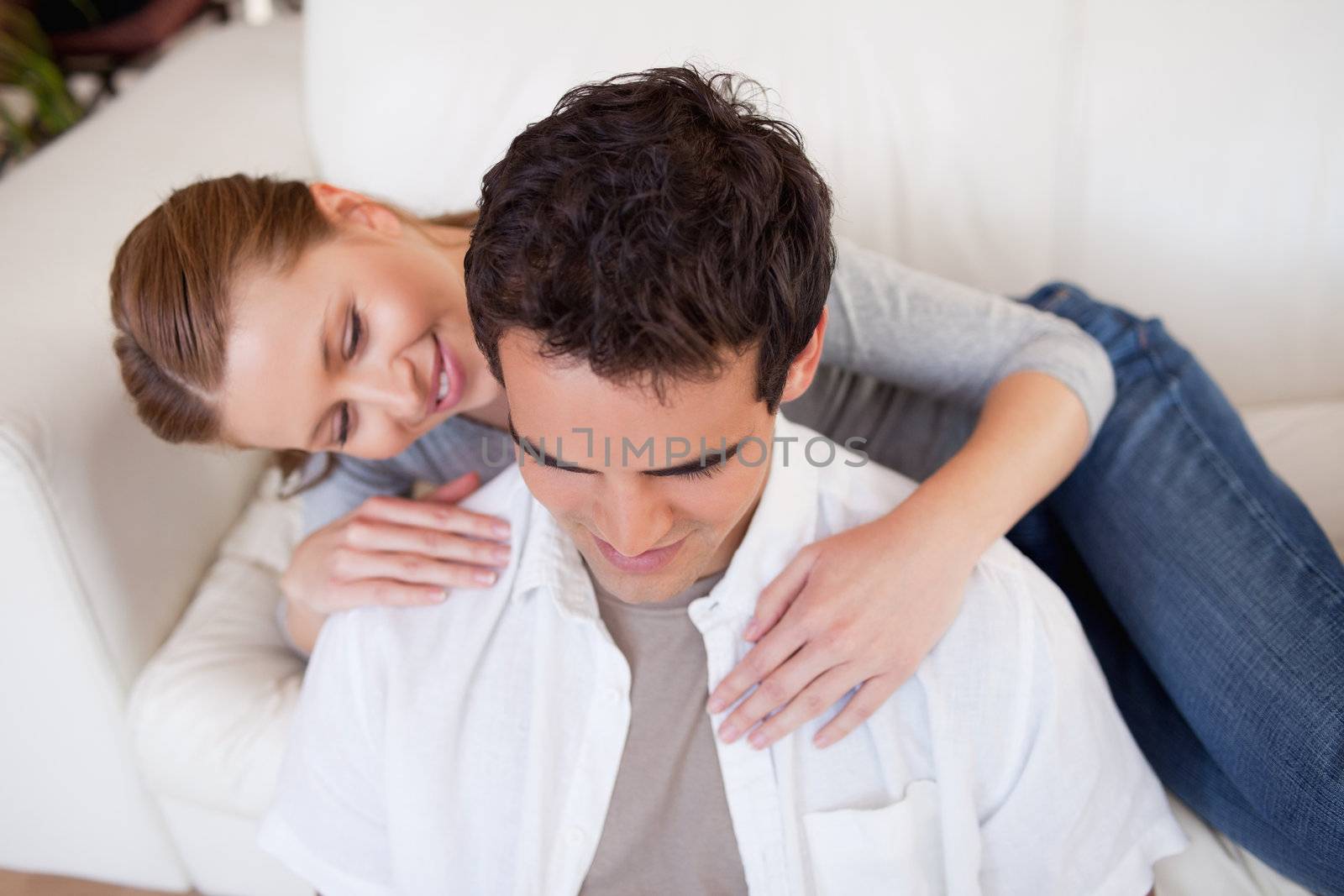 Young woman hugging her boyfriend on the couch