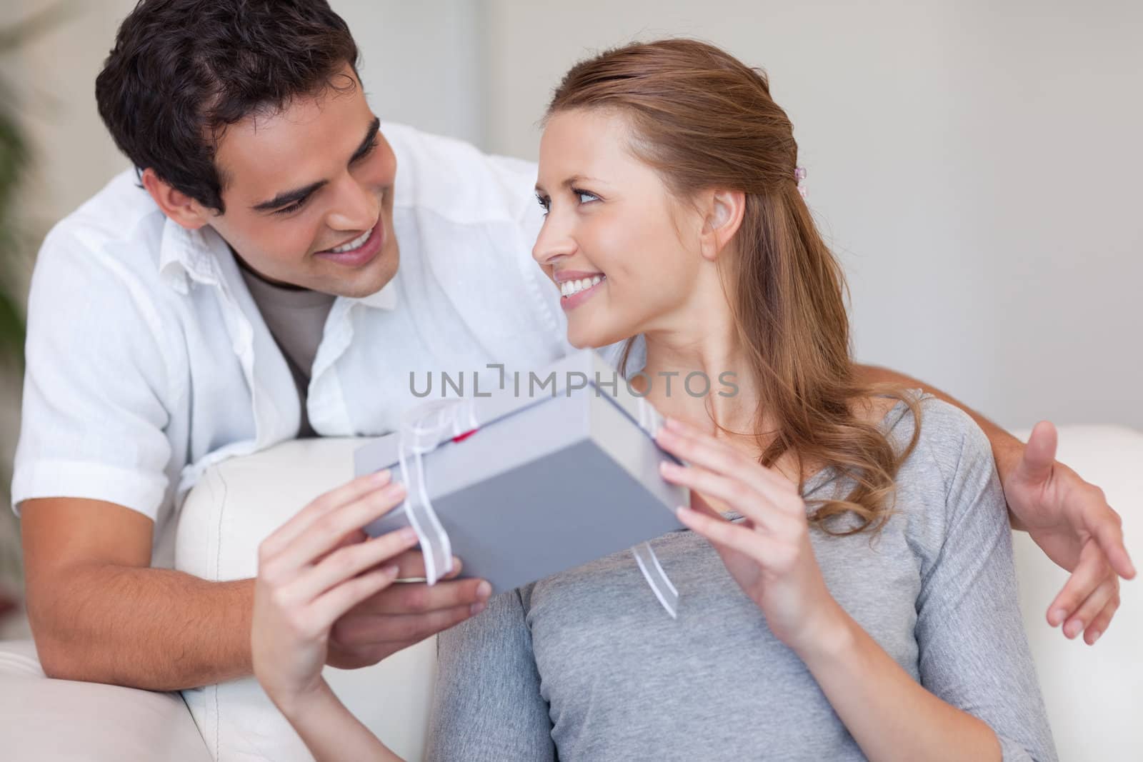 Young woman smiling happily about the present she just got from her boyfriend