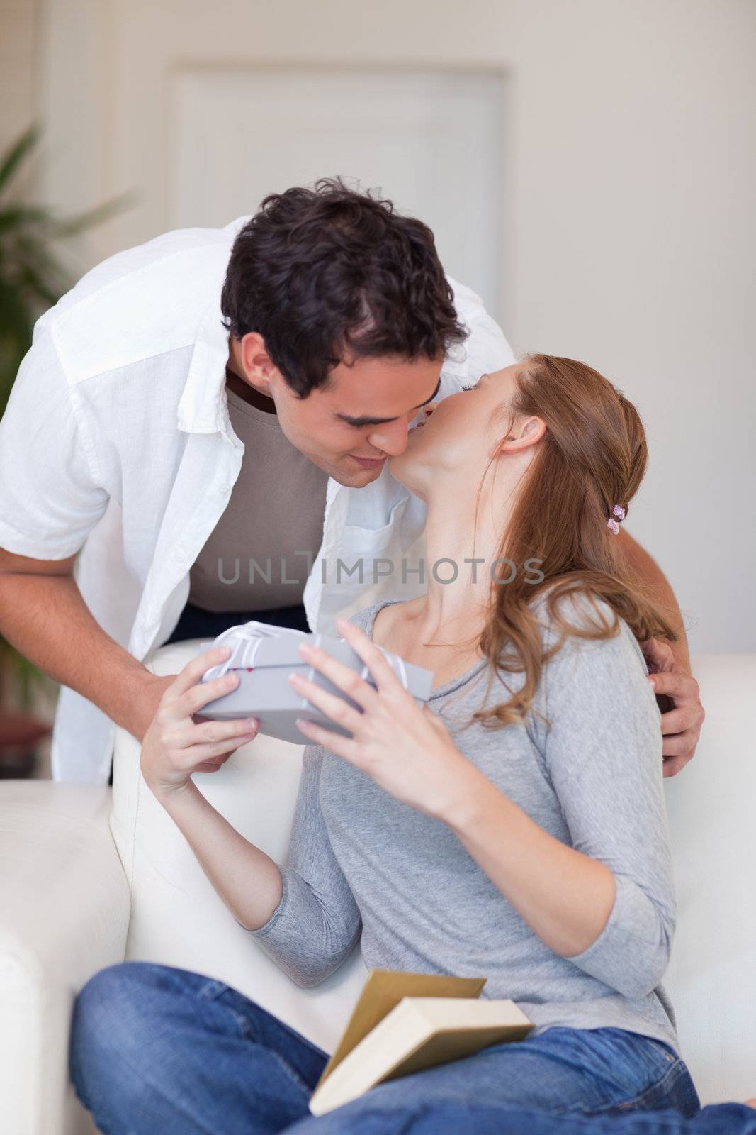 Young woman giving her boyfriend a small kiss as thanks for a present