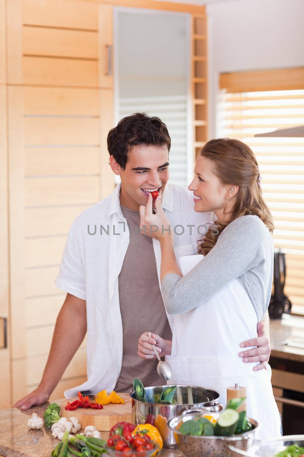 Young man trying the meal his girlfriend is preparing