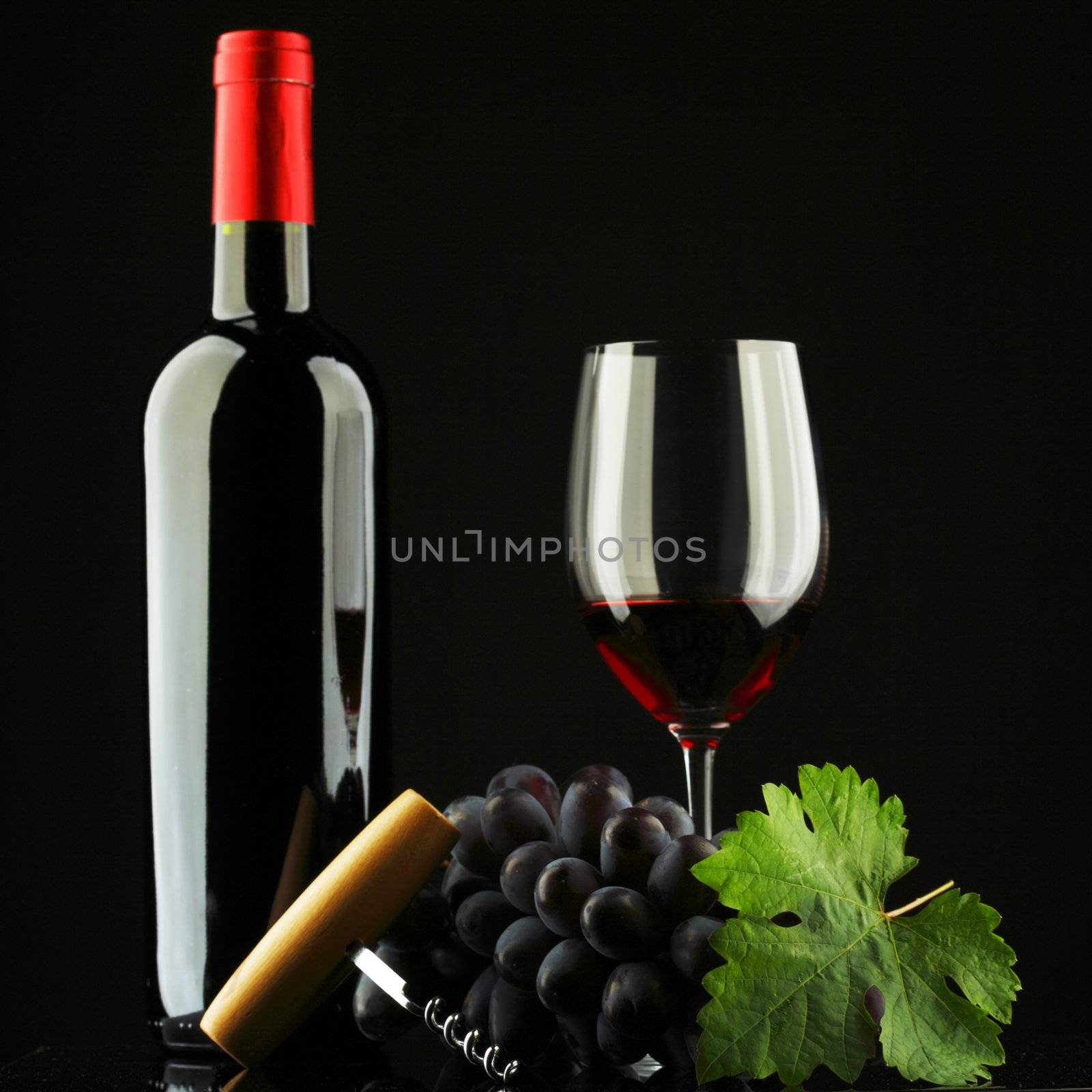 bottle with red wine and glass and grapes
