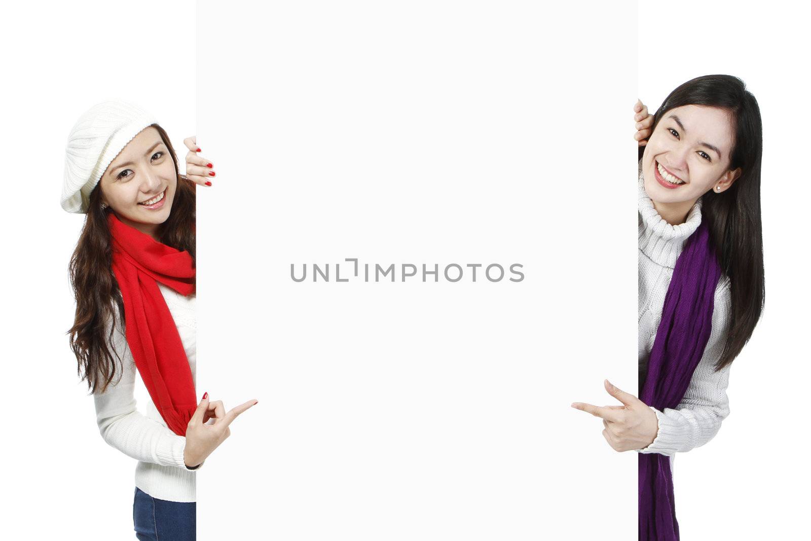 Blank space between two young women wearing winter or holiday attire
