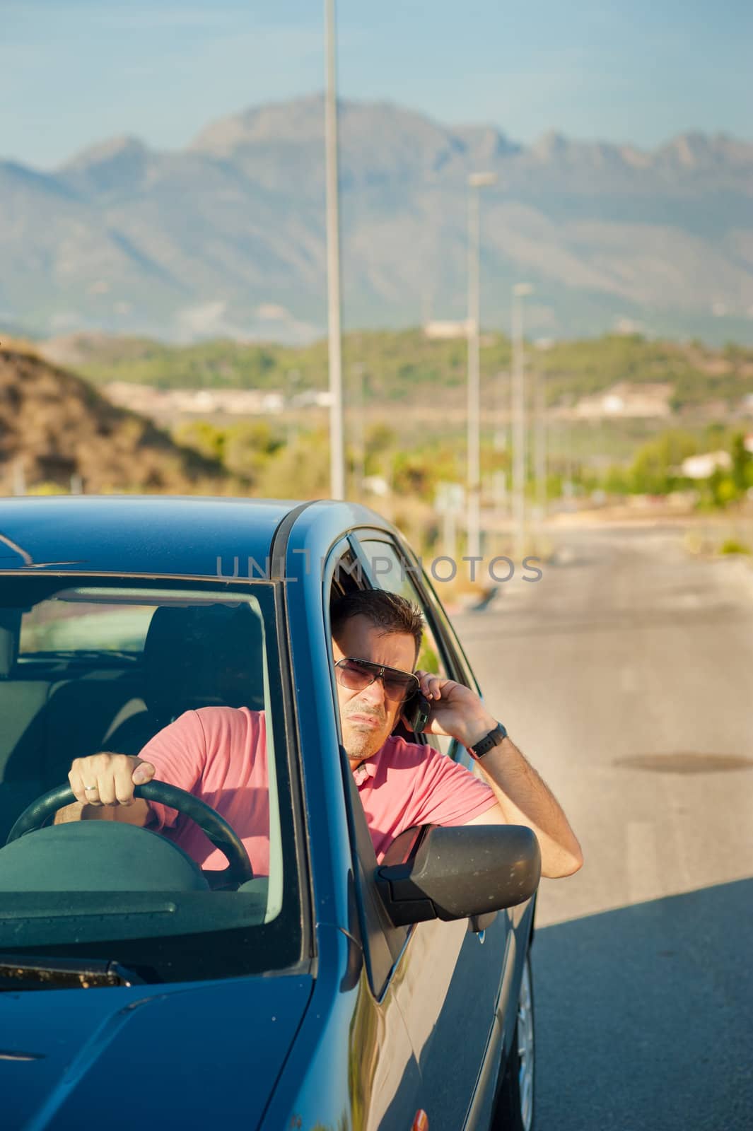 Cool looking guy using is phone while driving