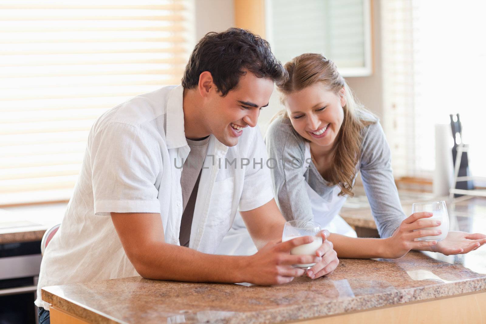 Young couple having a glass of milk in the kitchen