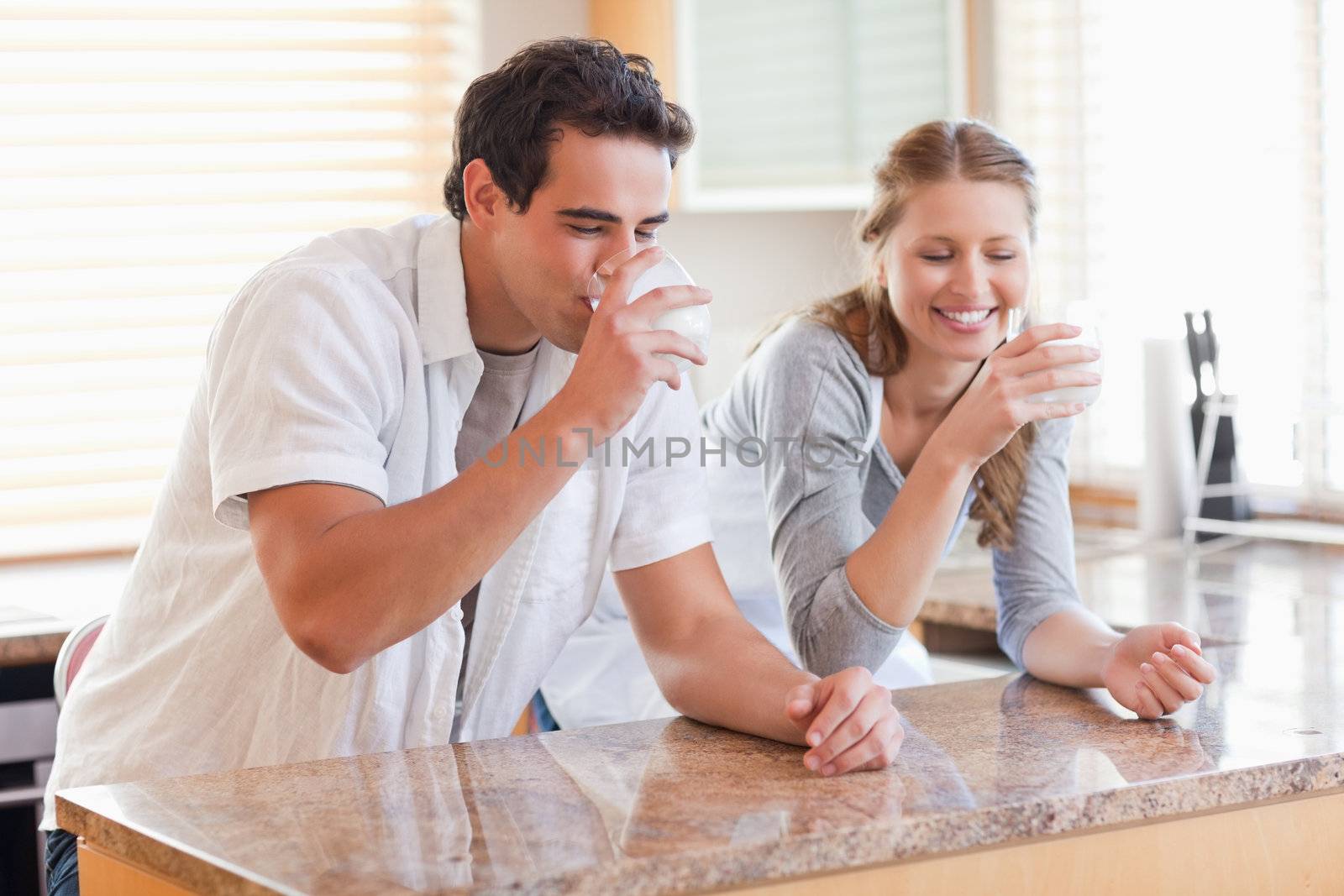 Young couple drinking milk in the kitchen