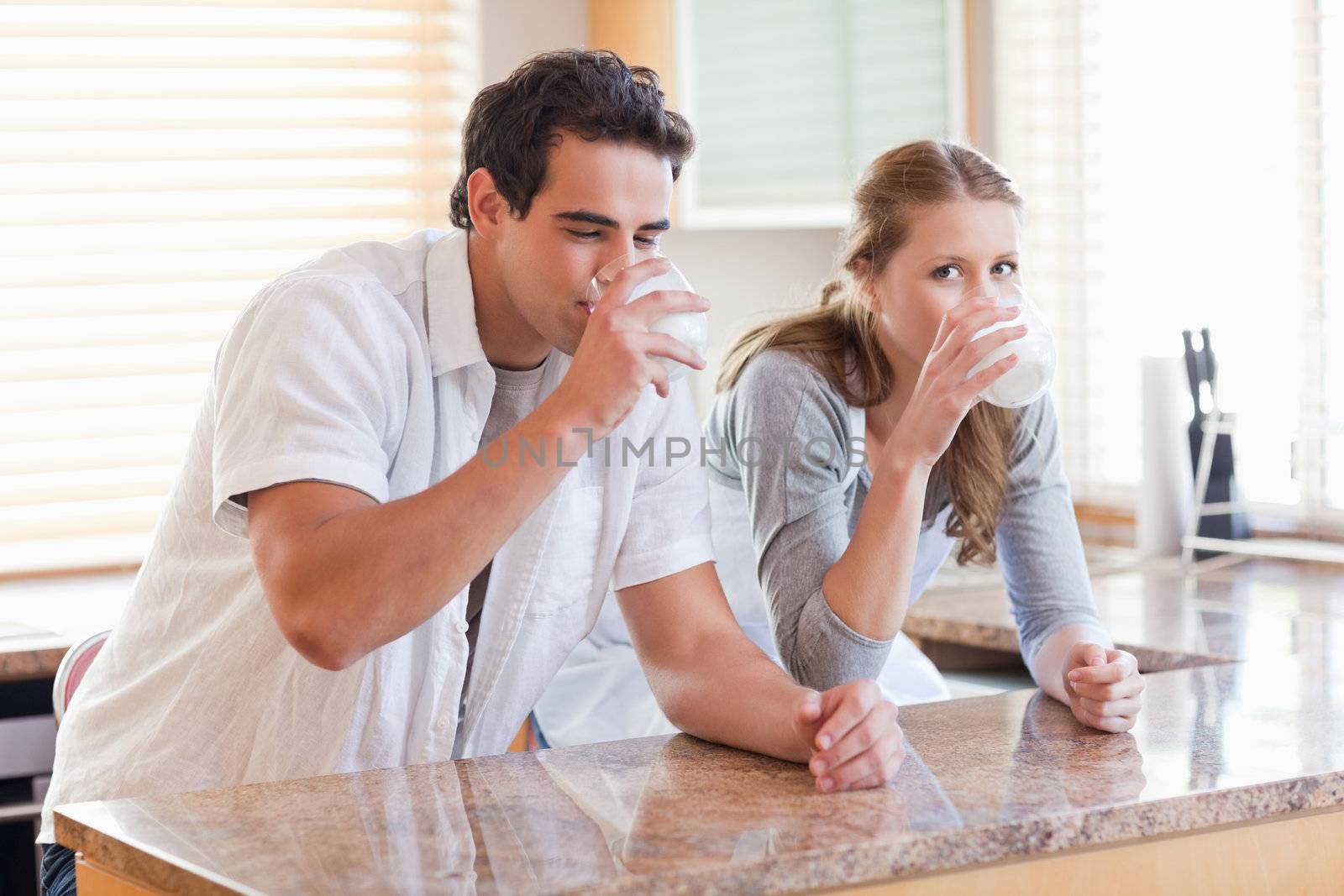 Young couple enjoying some milk in the kitchen