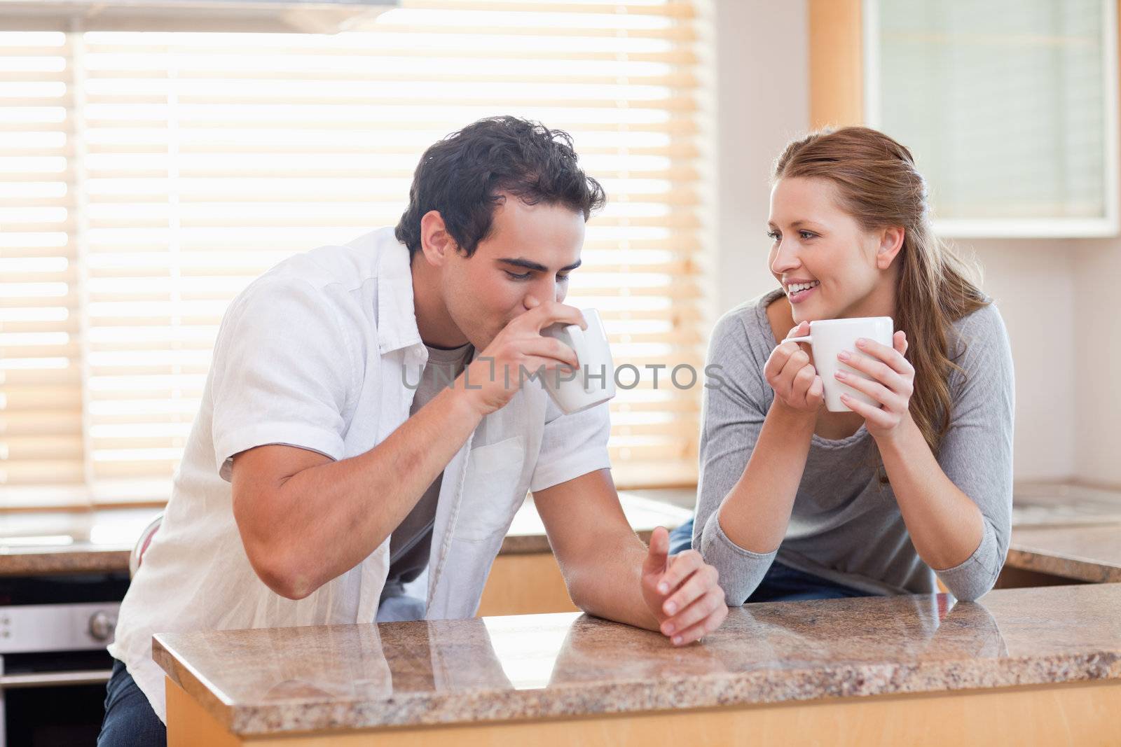 Young couple drinking coffee in the kitchen