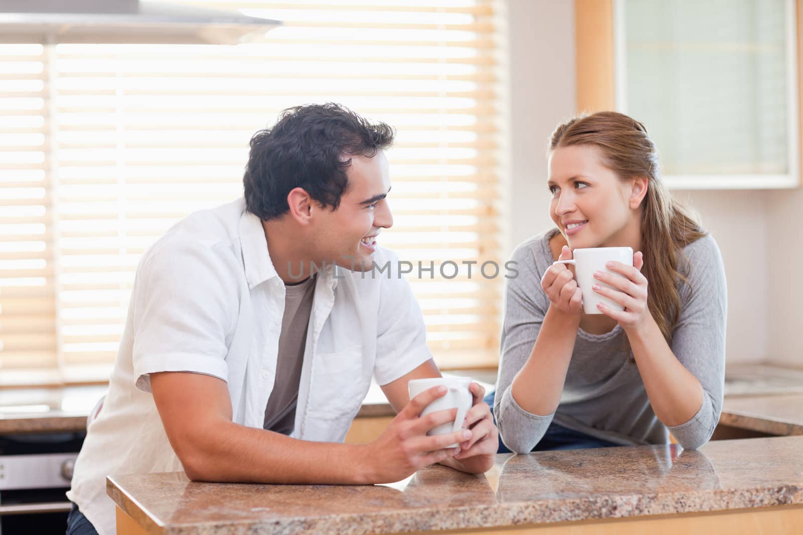 Young couple enjoying coffee in the kitchen together