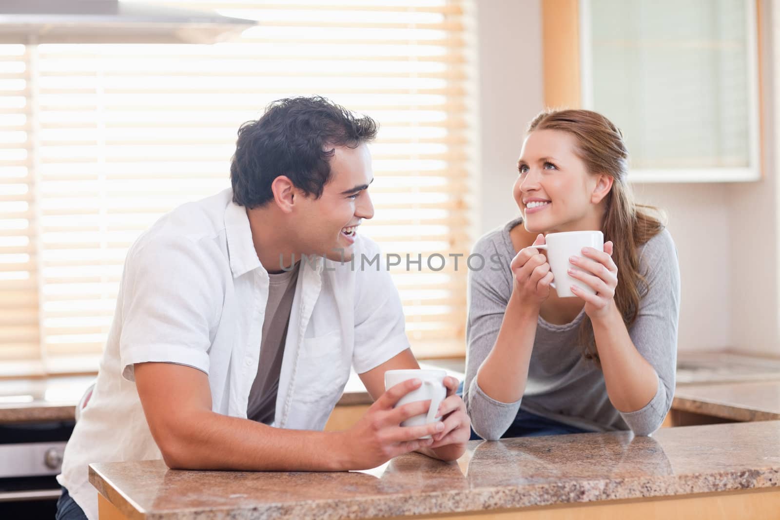 Cheerful young couple having coffee together