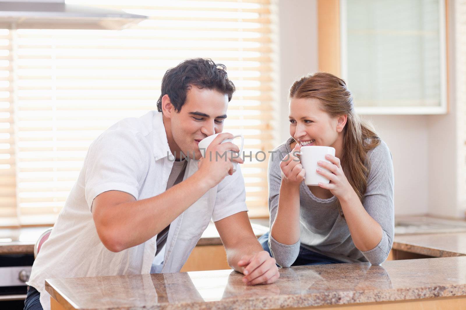 Young couple drinking in the kitchen