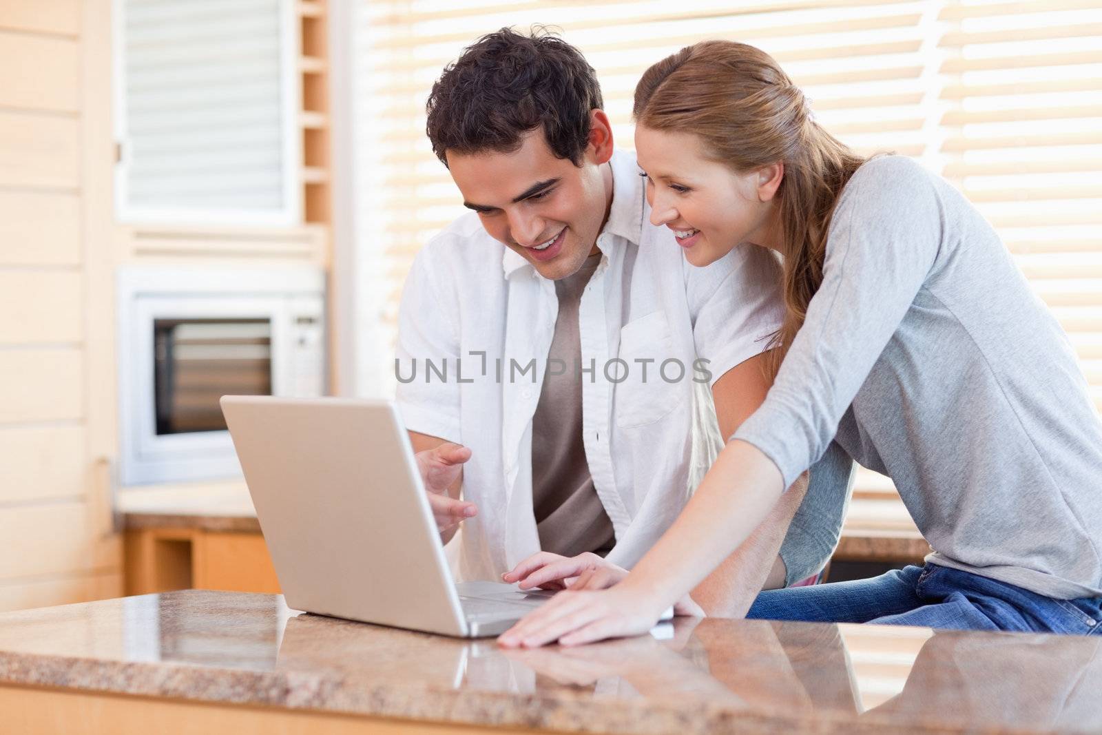 Young couple surfing the internet in the kitchen
