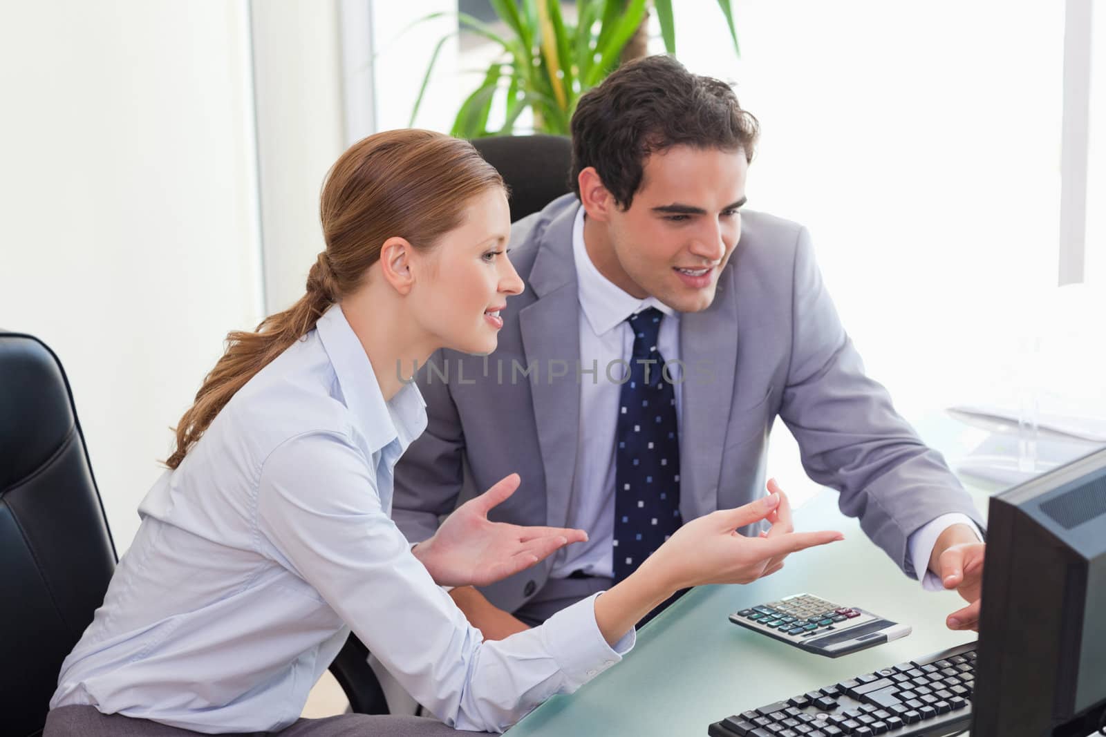 Young colleagues talking about computer problems