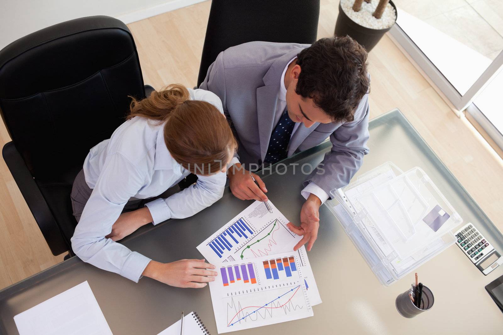 Above view of young consultant analyzing data with her client
