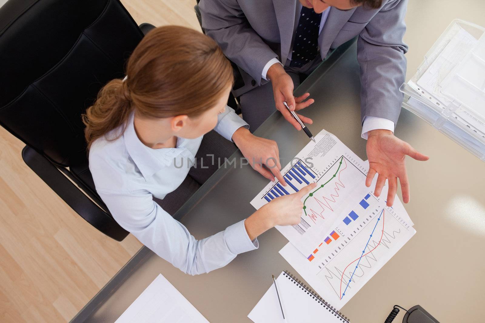 Above view of young business people analyzing statistics