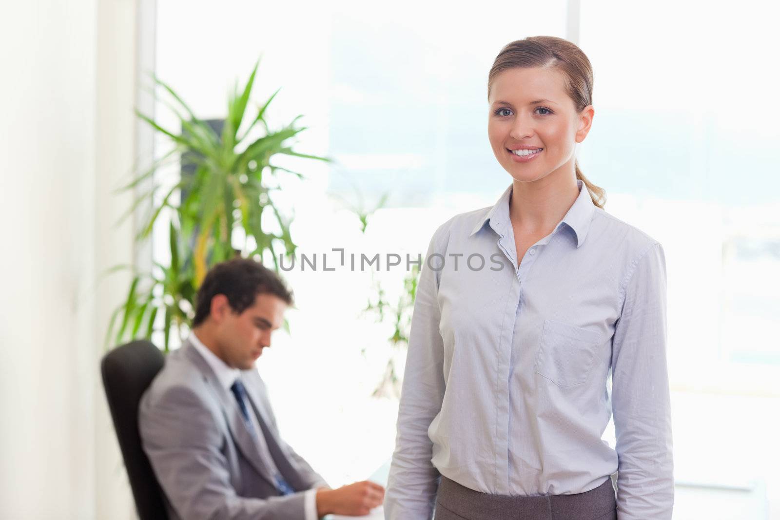 Young tradeswoman with colleague behind her