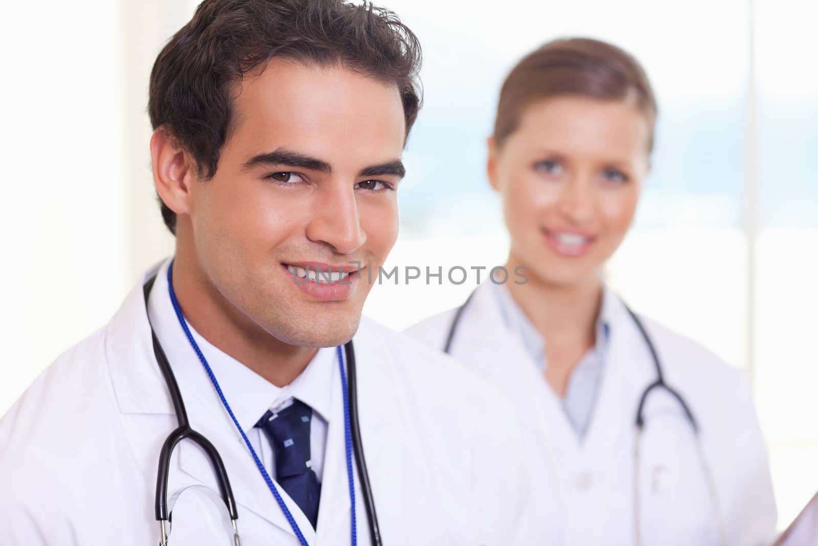 Smiling young medical assistants standing next to each other
