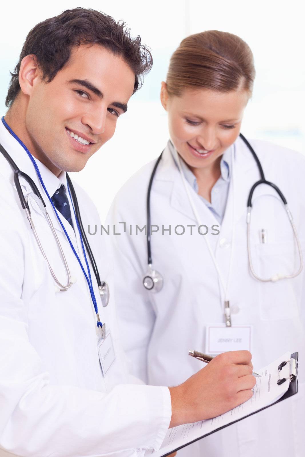 Young assistant doctors with patient record