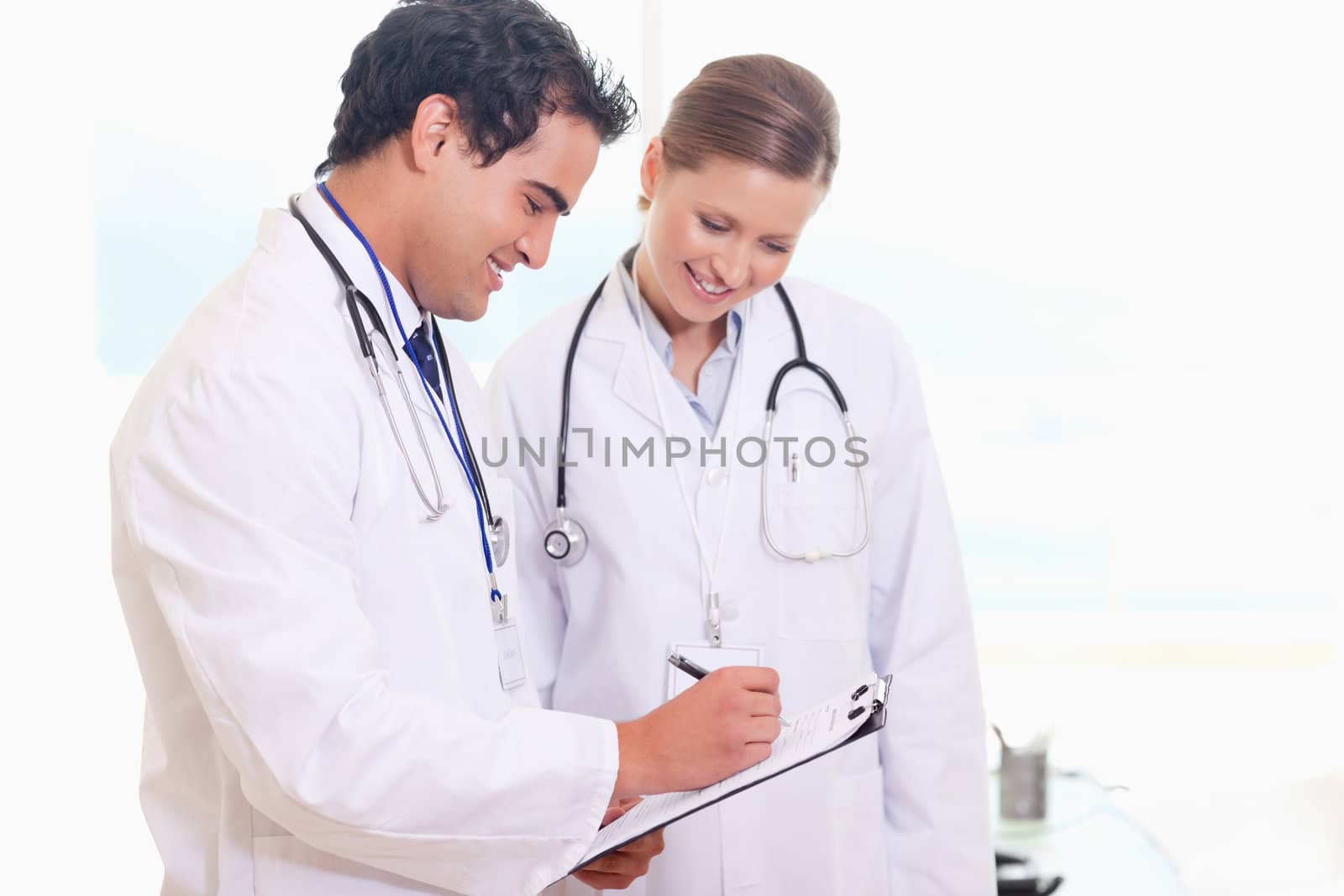 Smiling young medical staff working on patient record