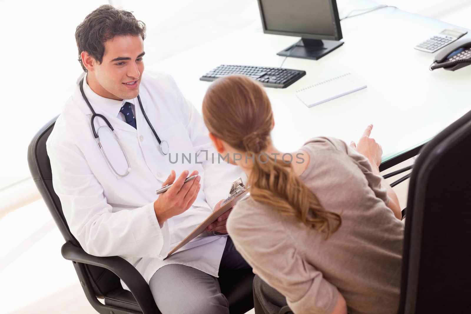 Young doctor asking his patient for symptoms 