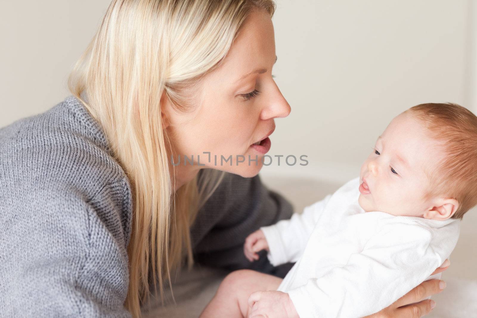 Side view of young mother laying down her newborn