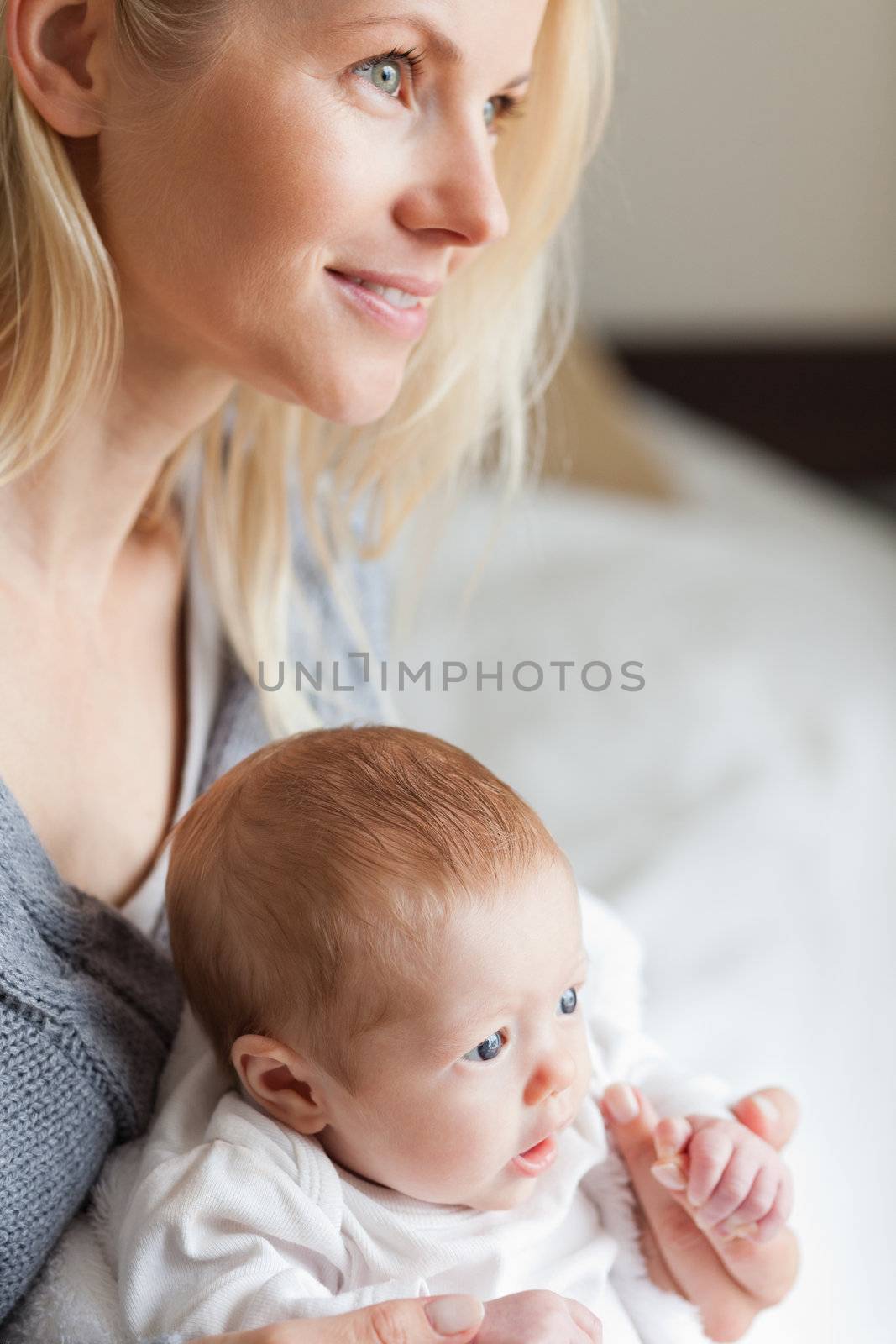 Young mother hugging her newborn