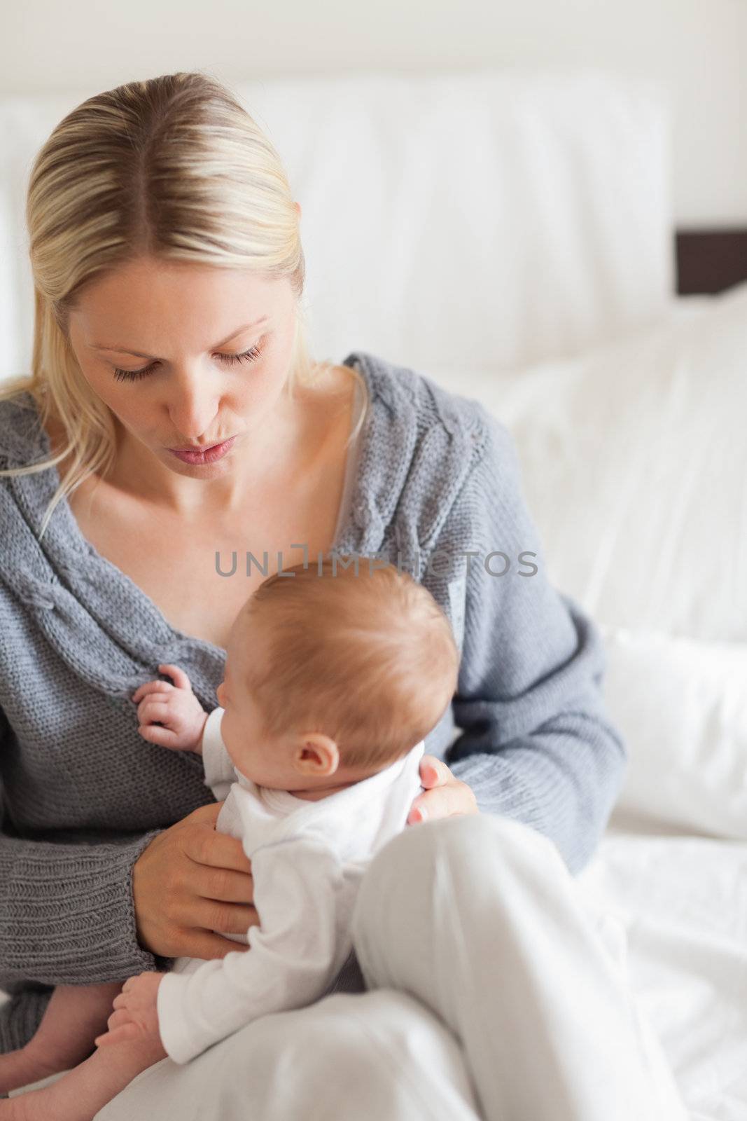 Affectionate young mother with newborn on her lap