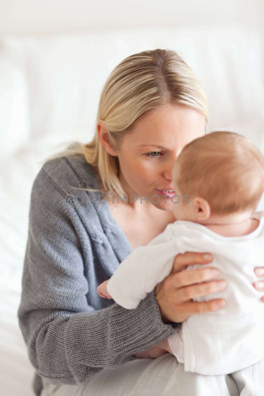 Affectionate young mother with baby on her lap