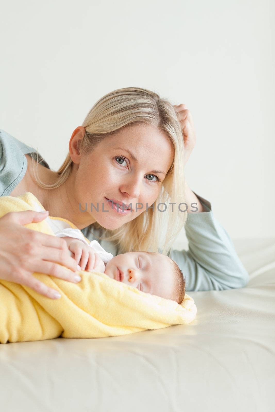 Young mom lying next to her sleeping baby