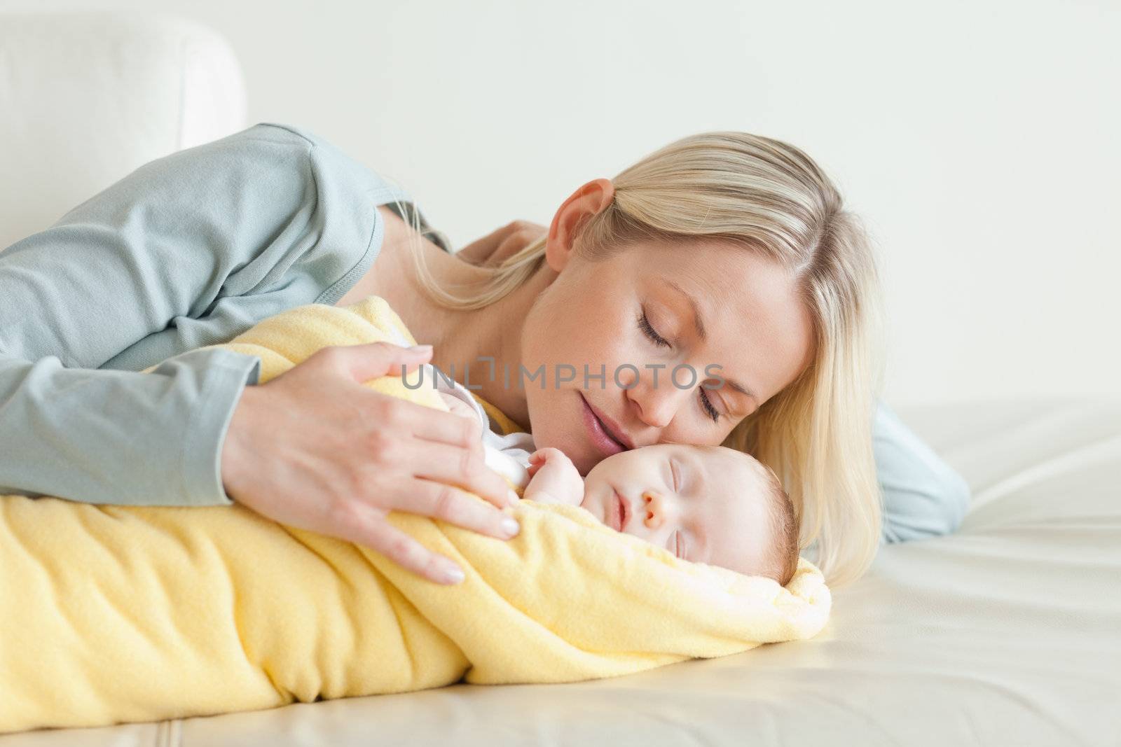 Young mother relaxing next to her sleeping baby
